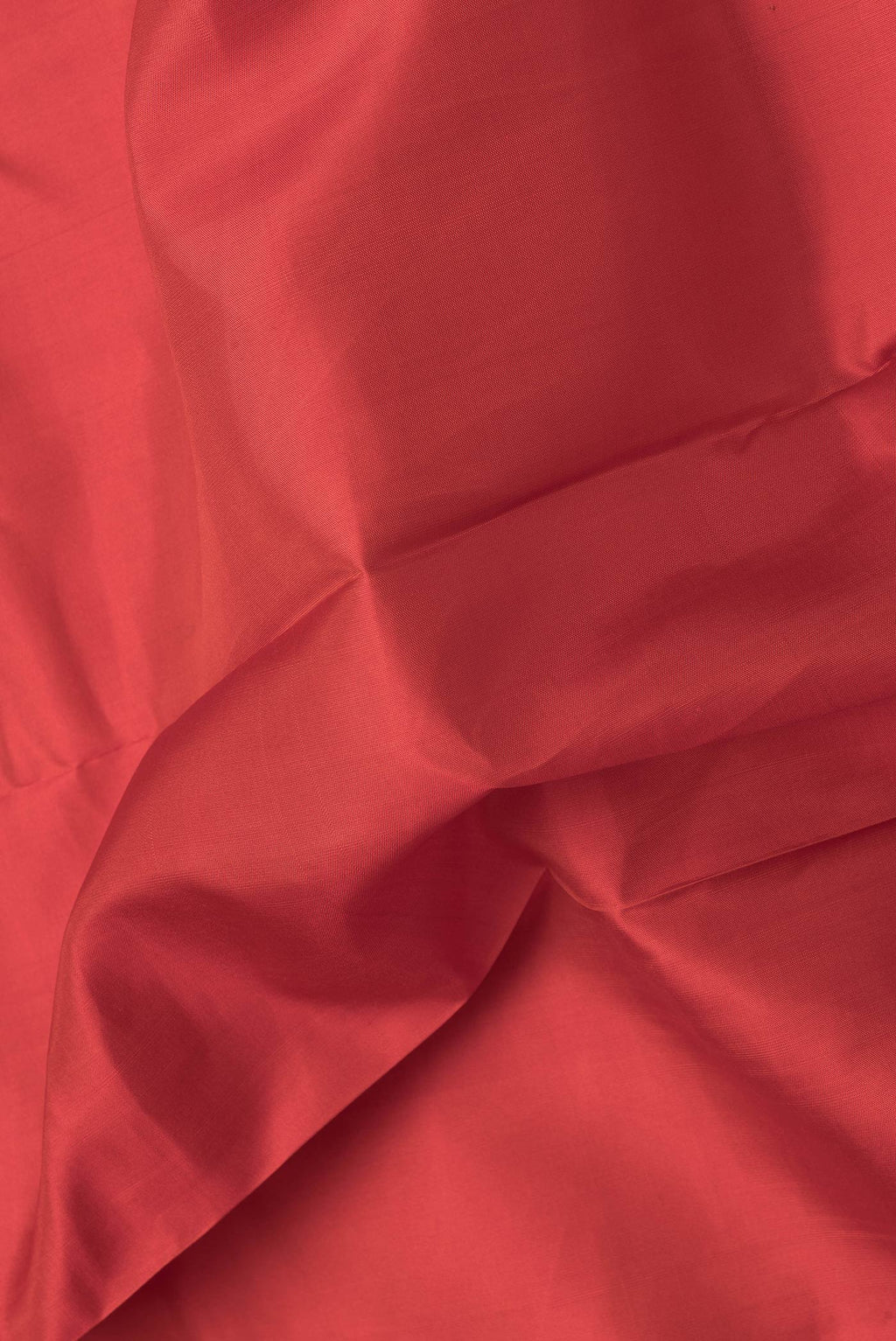 Close up of Orange Dual Tone Kanchipuram Silk Saree with Plain Body and Zari Border.  displaying folds