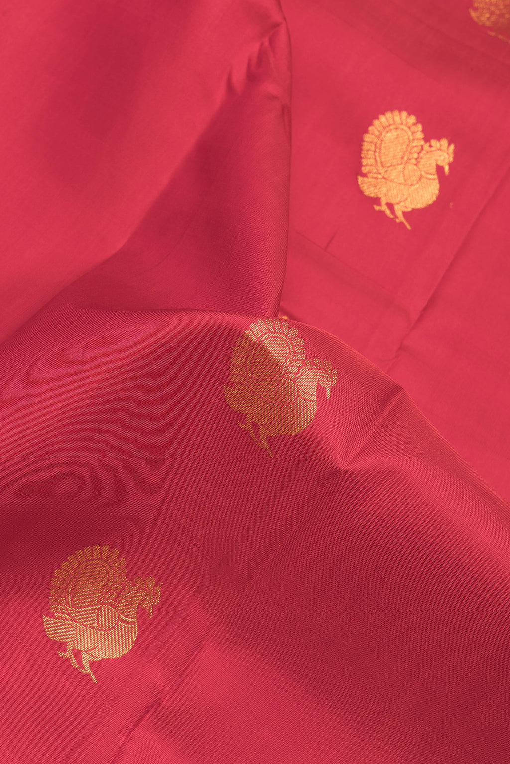 Close up of Red Dual Tone Kanchipuram Silk Saree with Zari Butta on the body and Zari Border.  displaying folds