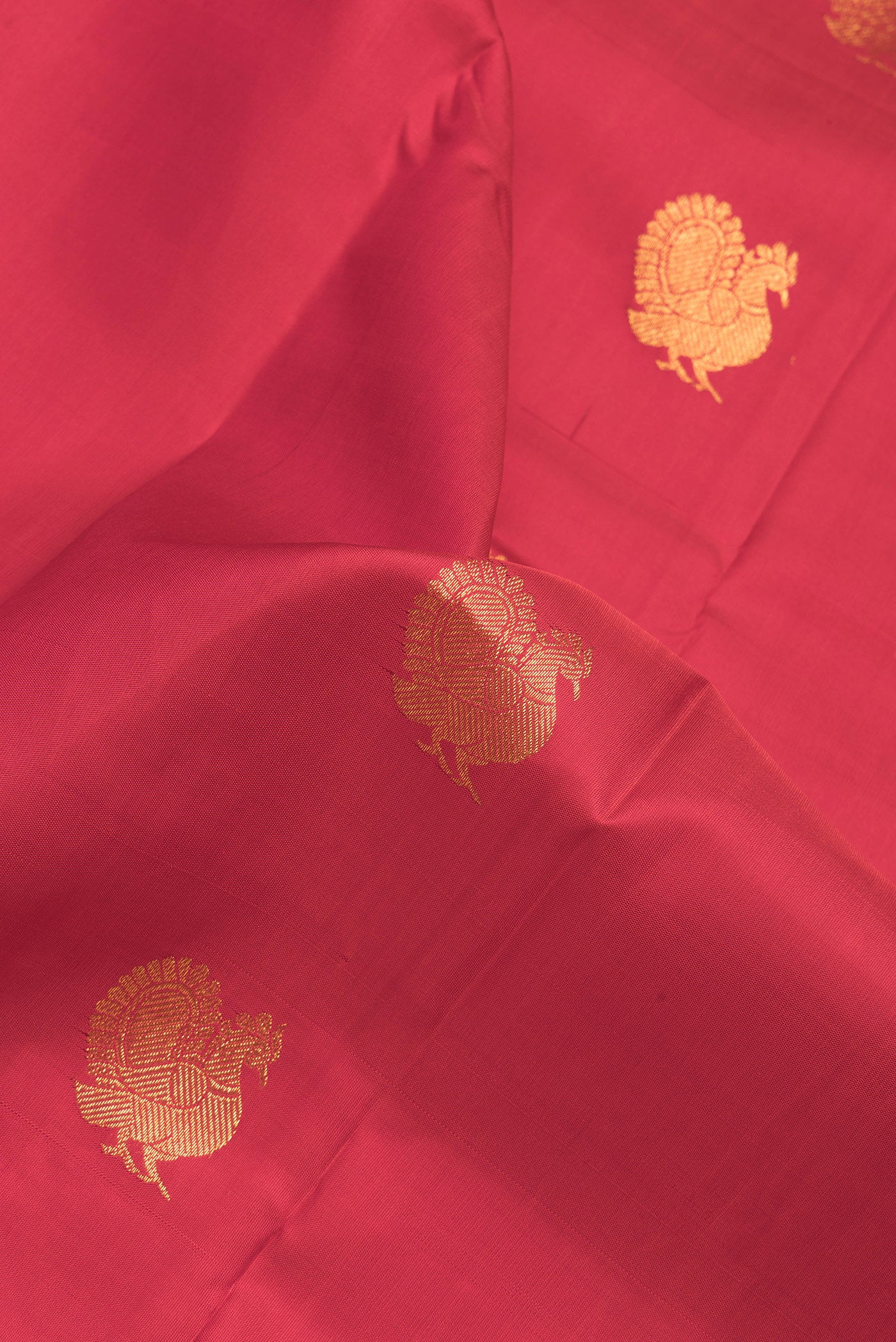 Close up of Red Dual Tone Kanchipuram Silk Saree with Zari Butta on the body and Zari Border.  displaying folds