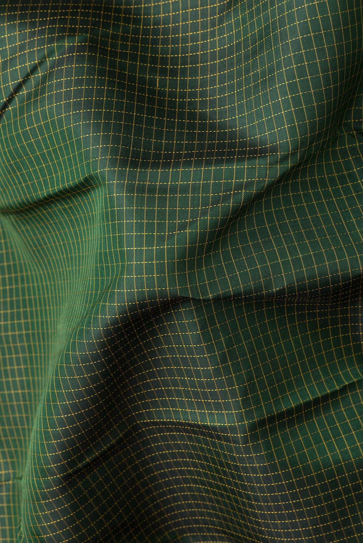 Close up of Bottle Green Dual Tone Kanchipuram Silk Saree with Checked design on the body and Zari Border.  displaying folds