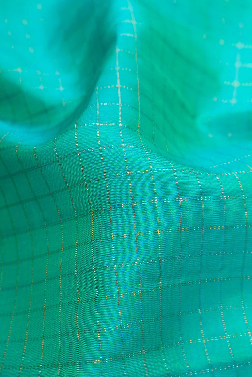 Close up of Sea Green Dual Tone Kanchipuram Silk Saree with Checked design on the body and Zari Border.  displaying folds