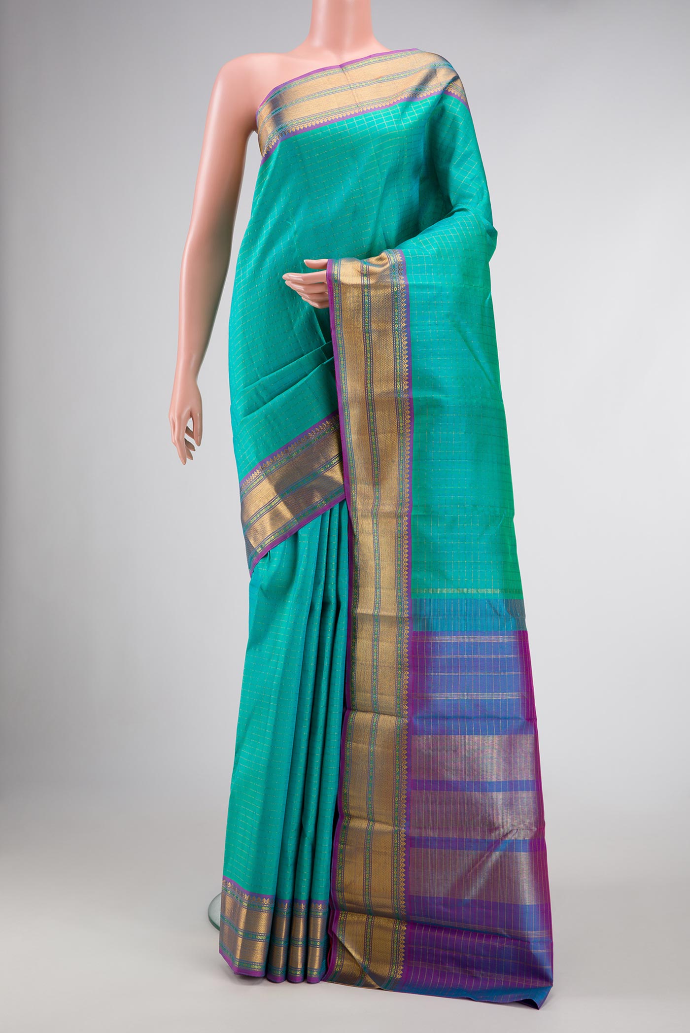 Sea Green Dual Tone Kanchipuram Silk Saree with Checked design on the body and Zari Border.  displayed on a mannequin
