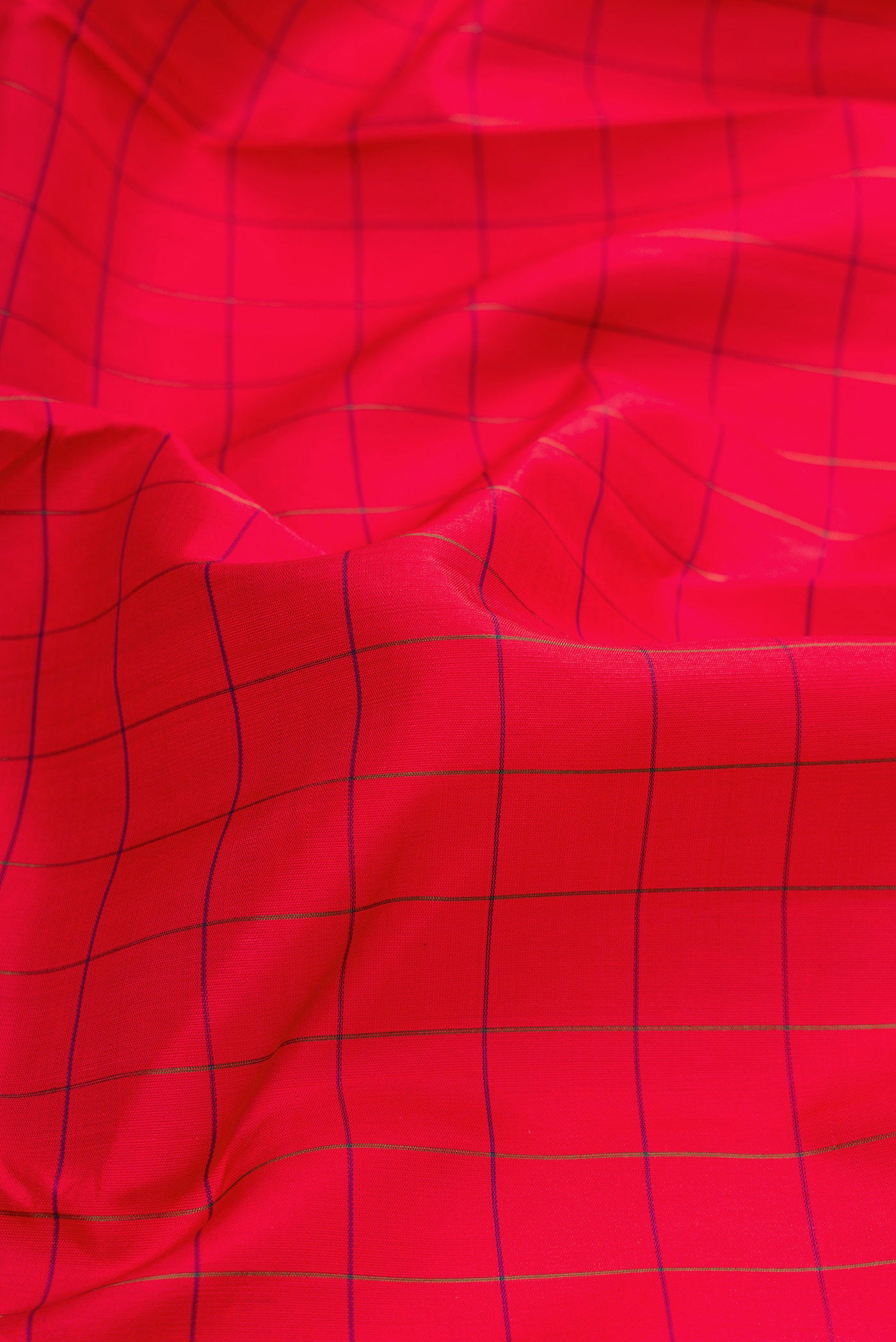 Close up of Red Dual Tone Kanchipuram Silk Saree with Checked design on the body and Zari Border.  displaying folds