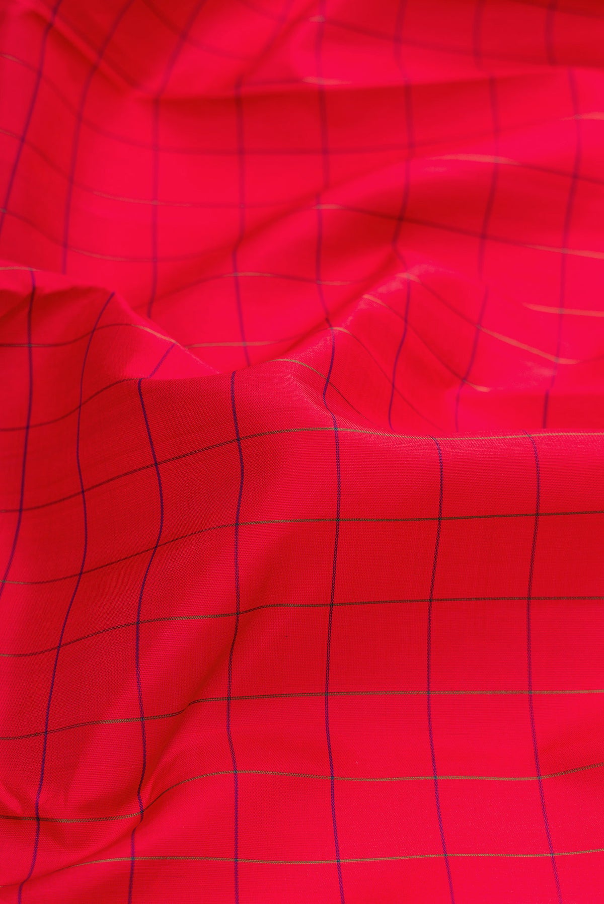 Close up of Red Dual Tone Kanchipuram Silk Saree with Checked design on the body and Zari Border.  displaying folds