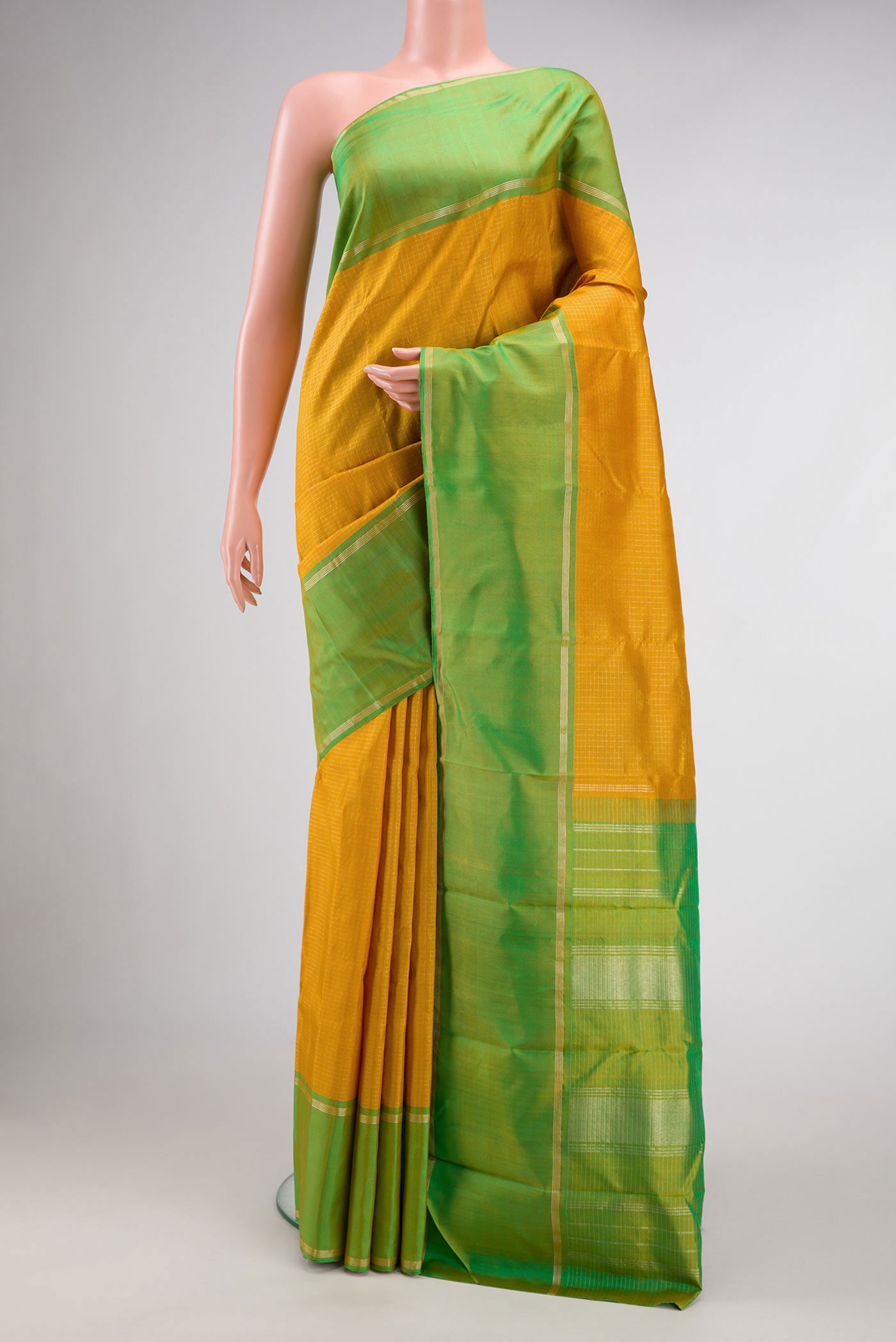 Mustard Dual Tone Kanchipuram Silk Saree with Checked design on the body and Zari Border.  displayed on a mannequin