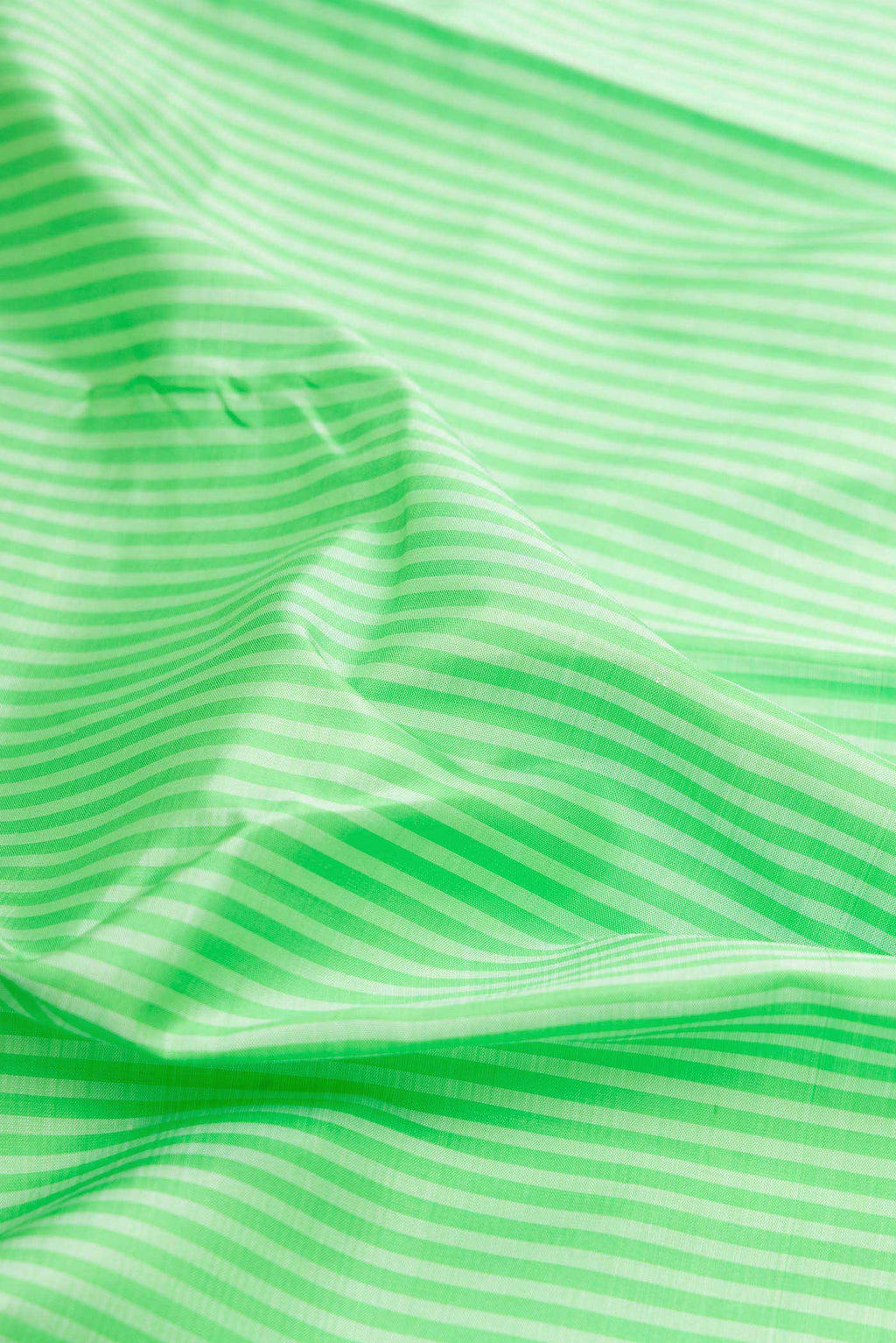 Close up of Pure Silk Pure Zari Parrot Green Dual Tone Kanchipuram Saree with Stripes on the body and Zari Border displaying folds