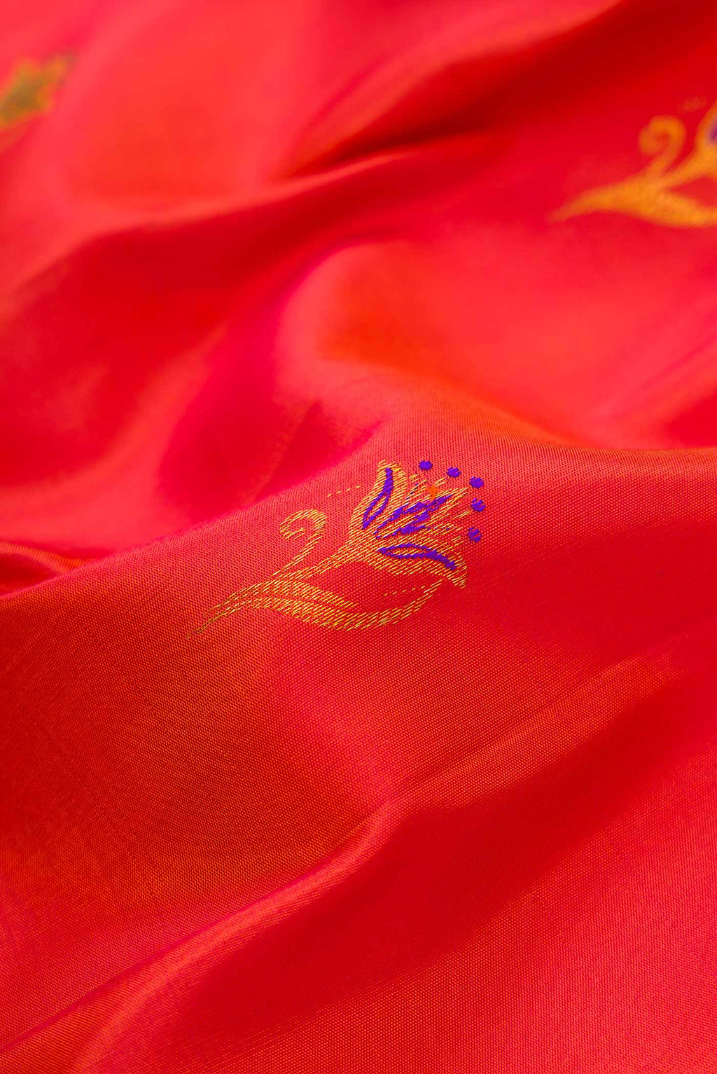 Close up of Orange Dual Tone Kanchipuram Silk Saree with Zari And Thread Butta on the body and Zari Border.  displaying folds