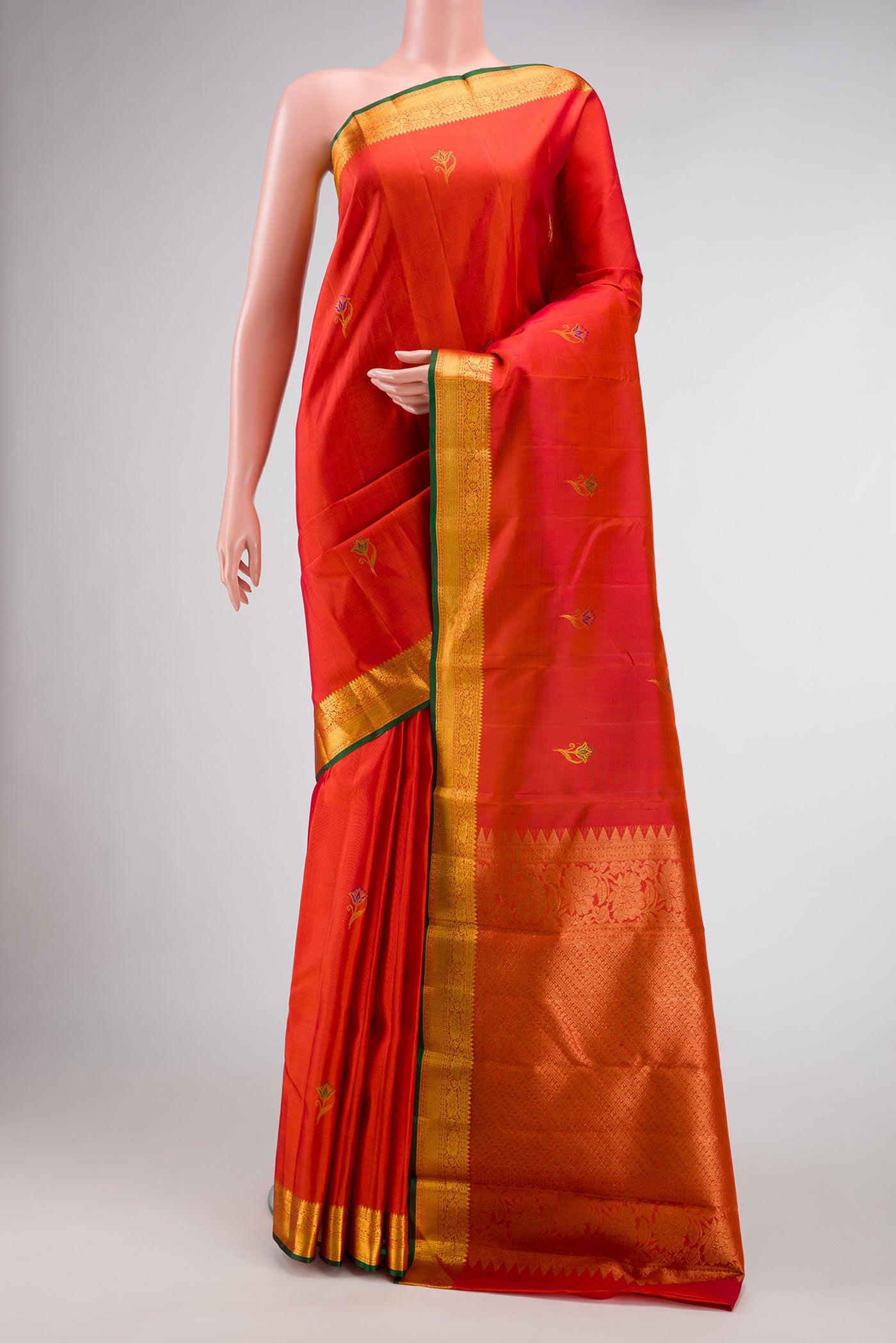 Orange Dual Tone Kanchipuram Silk Saree with Zari And Thread Butta on the body and Zari Border.  displayed on a mannequin