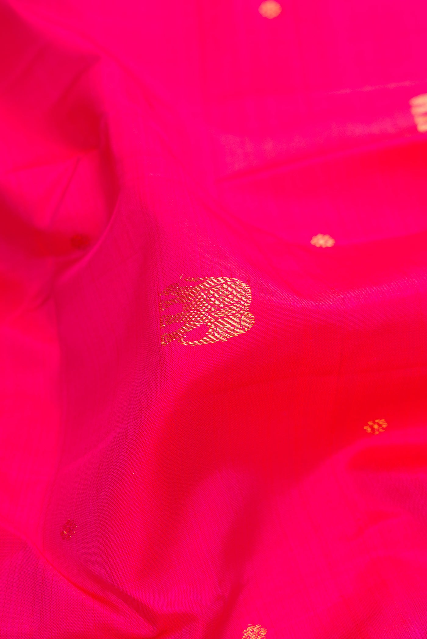 Close up of Pink Dual Tone Kanchipuram Silk Saree with Zari Butta on the body and Zari Border.  displaying folds