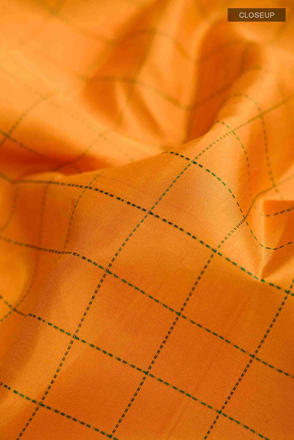 Close up of Mustard Kanchipuram Silk Saree with Checked design on the body and Ganga Jamuna Border displaying folds