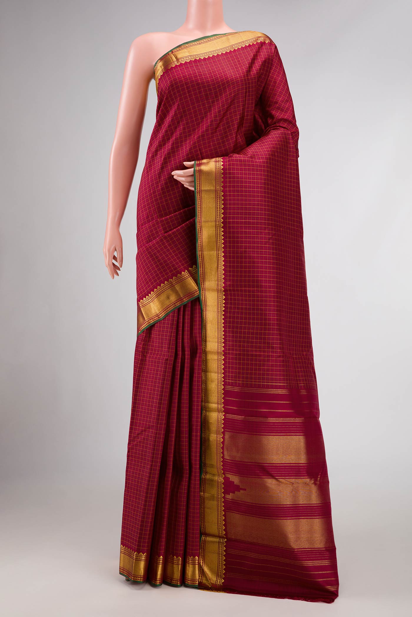Maroon Dual Tone Kanchipuram Silk Saree with Checked design on the body and Zari Border.  displayed on a mannequin