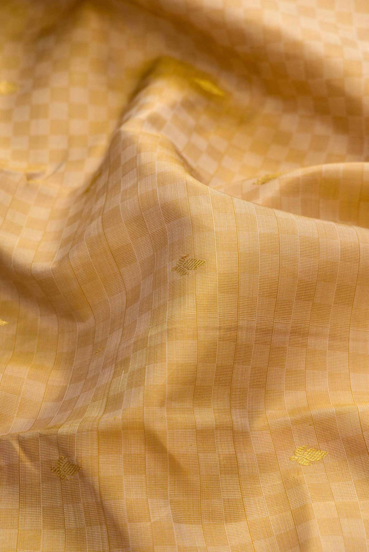 Close up of Beige Dual Tone Kanchipuram Silk Saree with Zari Butta on the body and Zari Border displaying folds