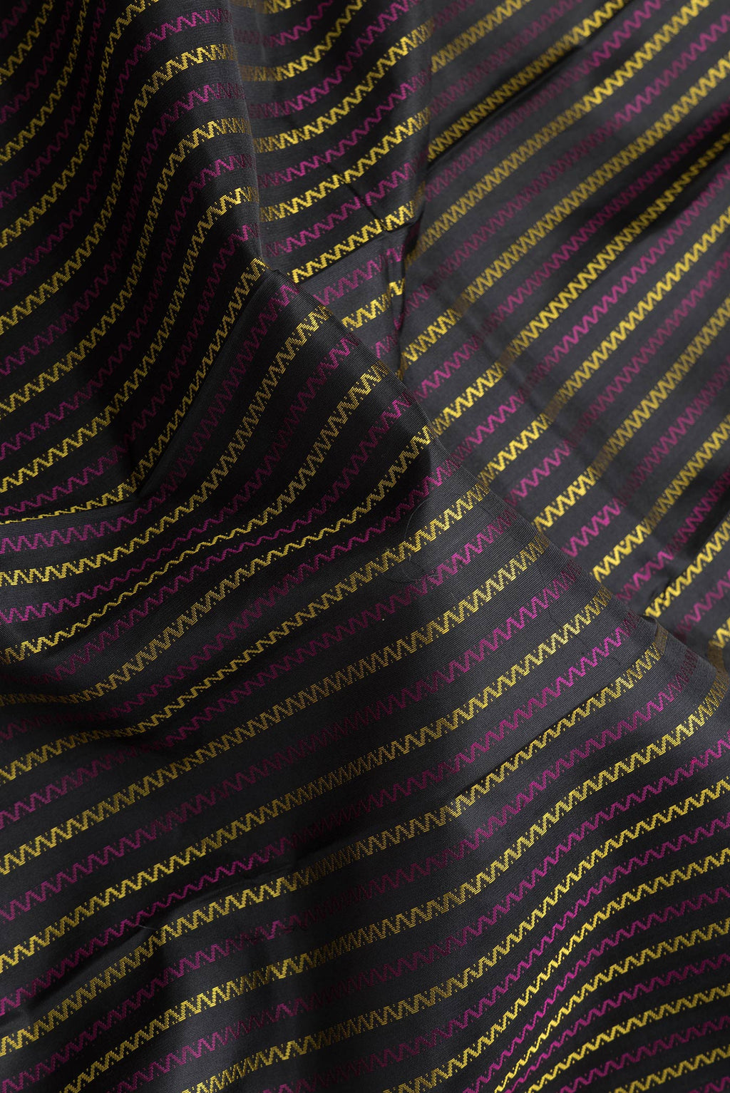Close up of Black Dual Tone Kanchipuram Silk Saree with Stripes on the body and Ganga Jamuna Border.  displaying folds