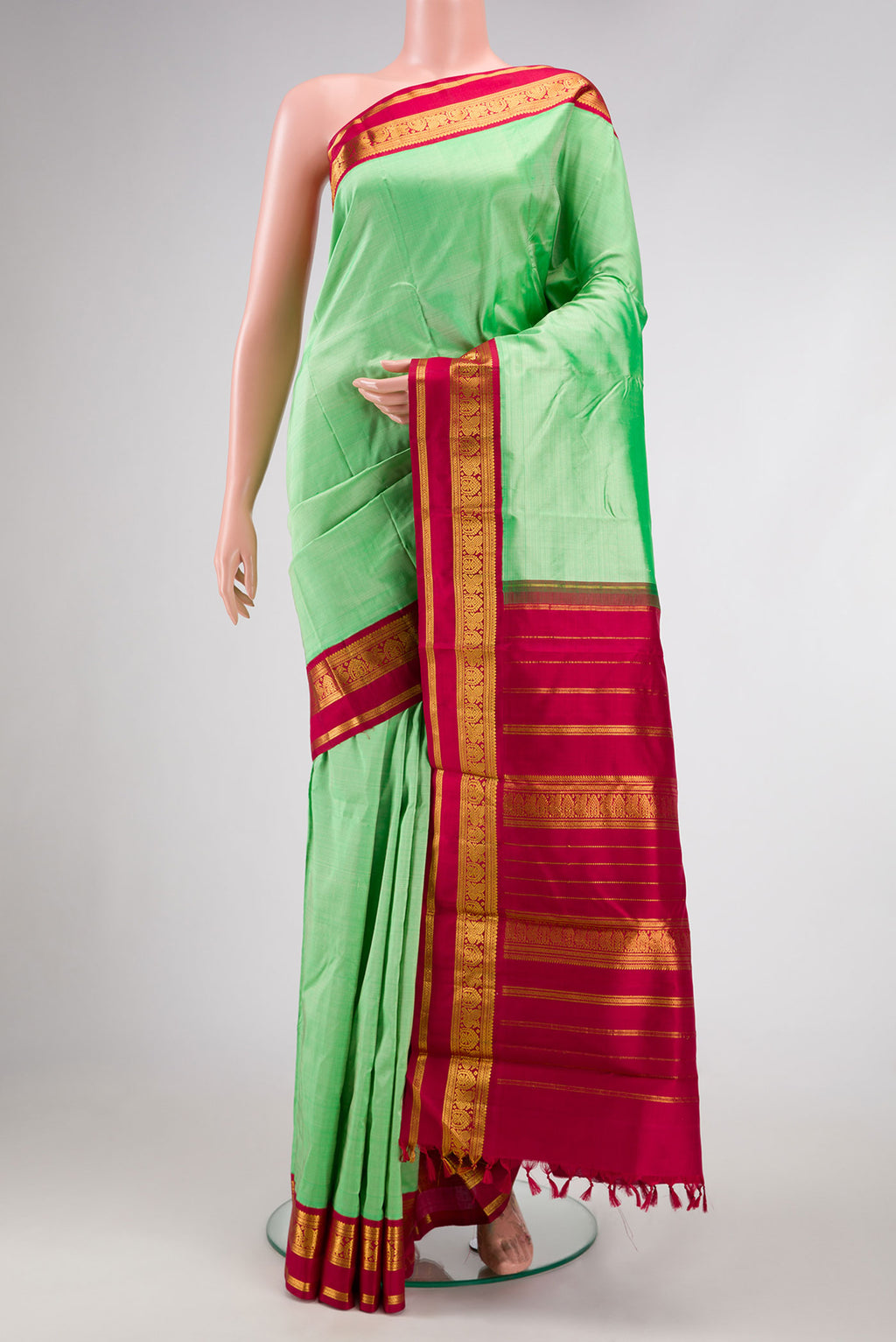 Pista Green Dual Tone Kanjivaram Silk Saree with Plain Body and Zari Border.  displayed on a mannequin