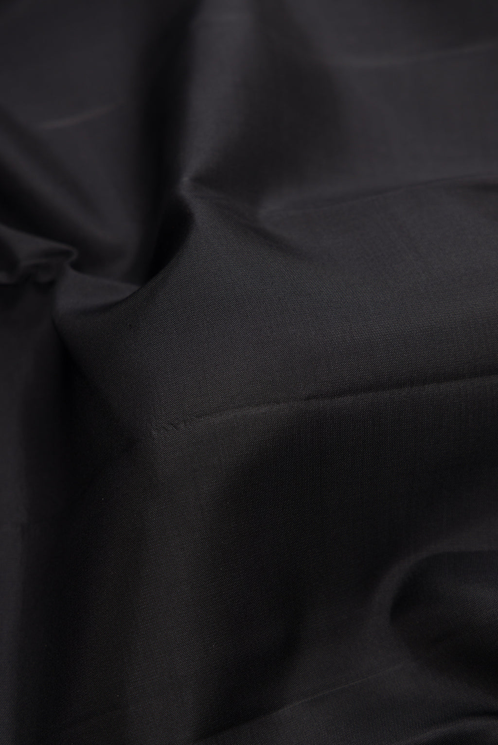 Close up of Black Dual Tone Kanchipuram Silk Saree with Plain Body and Fancy Border.  displaying folds