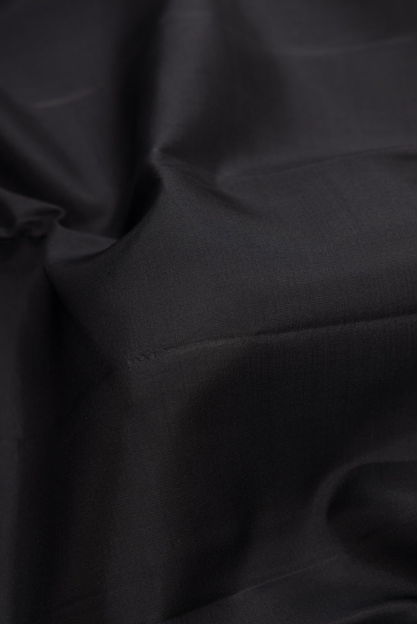 Close up of Black Dual Tone Kanchipuram Silk Saree with Plain Body and Fancy Border.  displaying folds