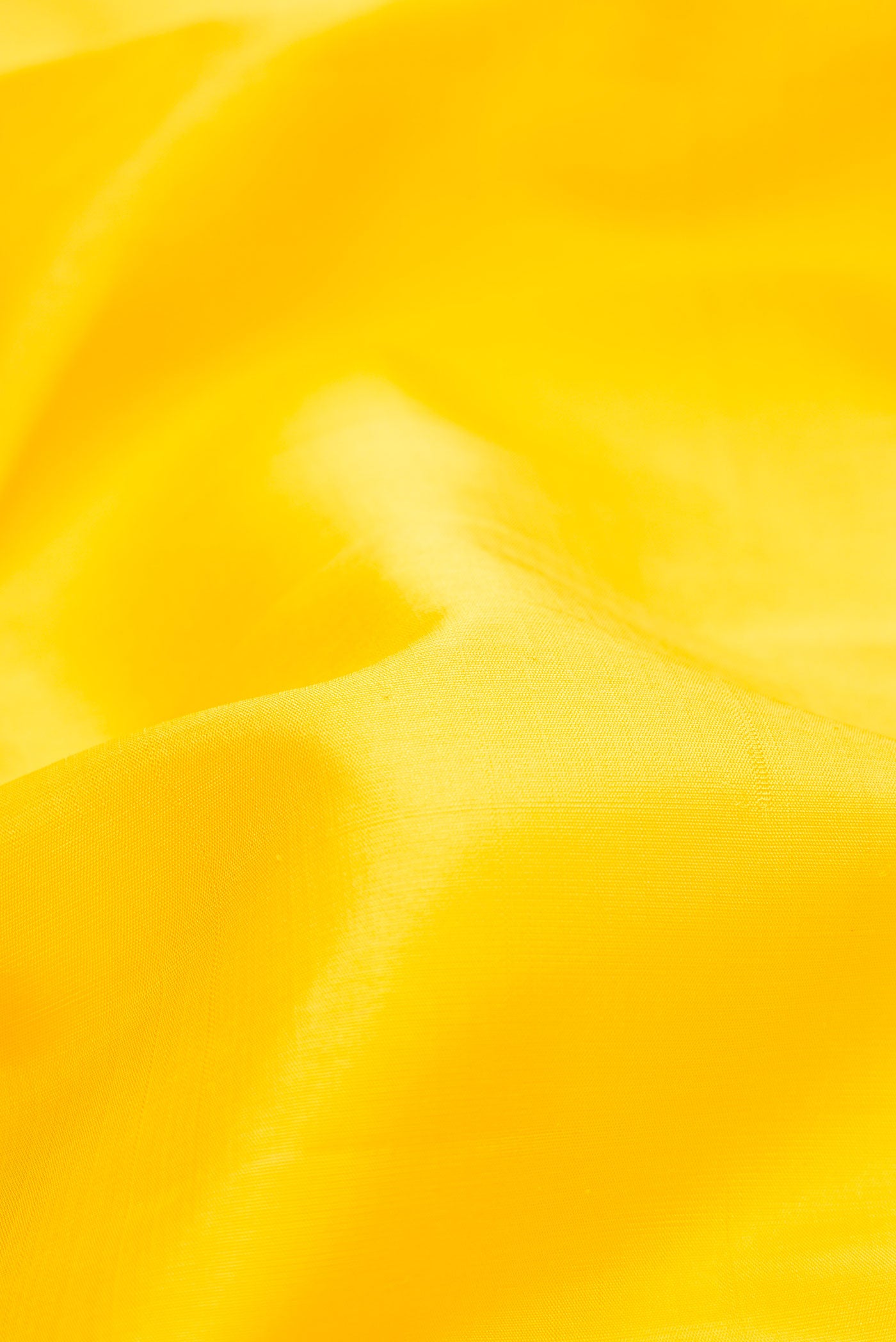 Close up of Pure Silk Pure Zari Yellow Dual Tone Kanjivaram Saree with Plain Body and Zari Border.  displaying folds