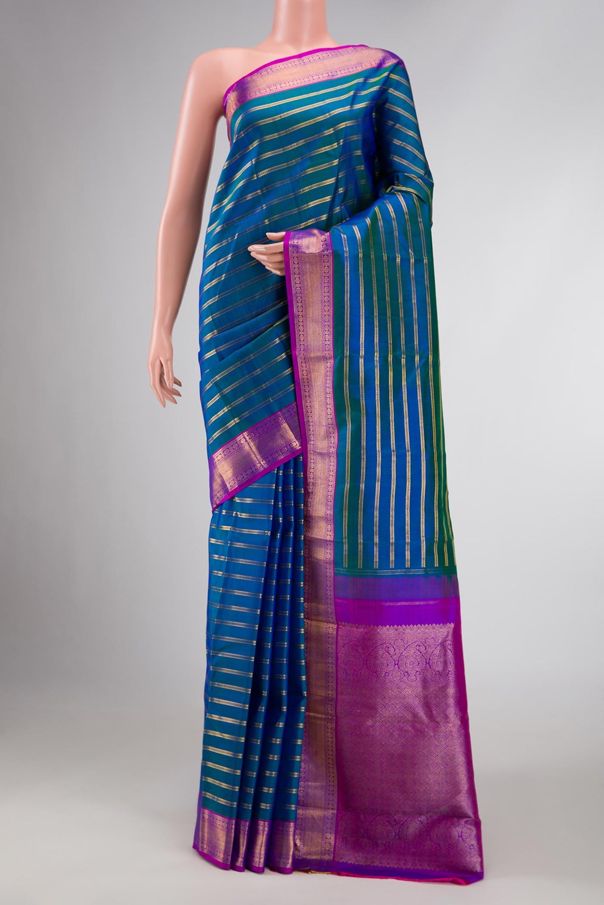 Peacock Blue Dual Tone Kanchipuram Silk Saree with Stripes on the body and Zari Border displayed on a mannequin