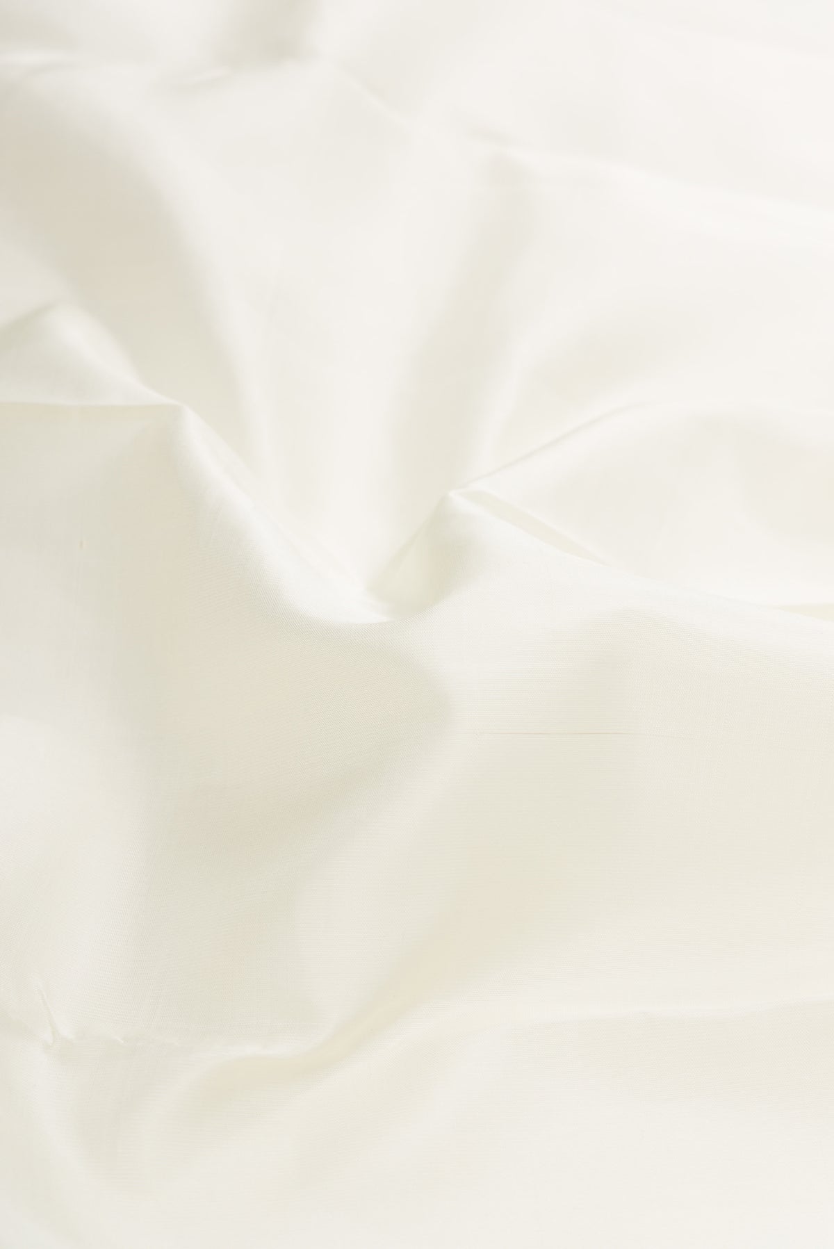Close up of Pure Silk Pure Zari White Dual Tone Kanjivaram Saree with Plain Body and Zari Border.  displaying folds