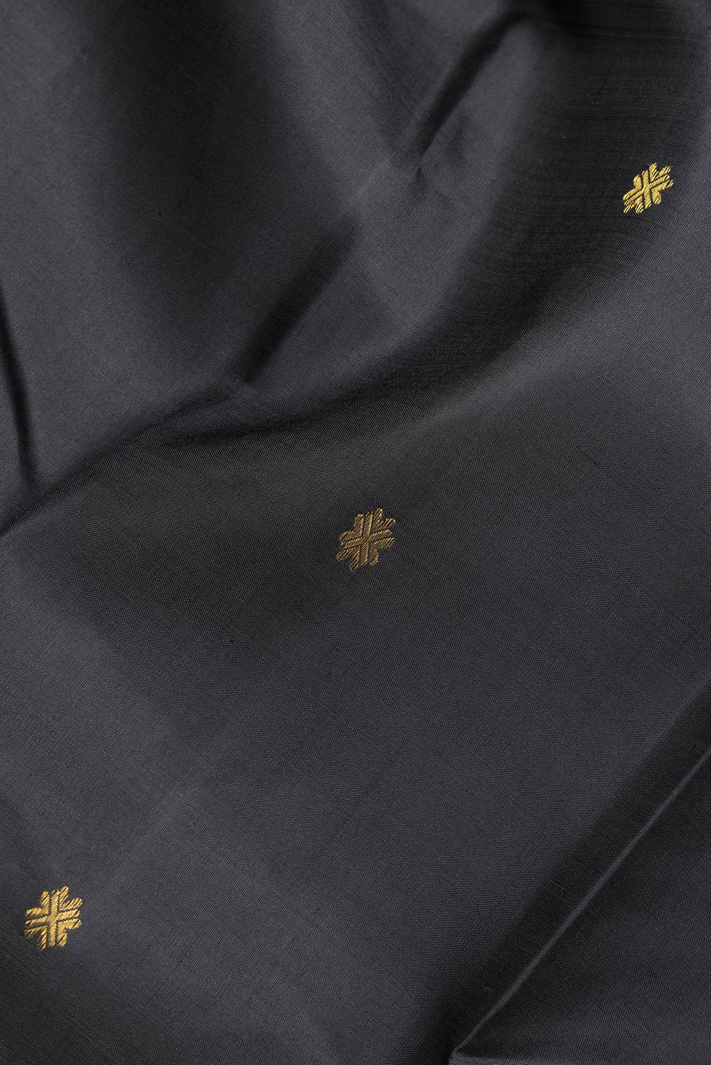 Close up of Black Dual Tone Kanchipuram Silk Saree with Zari Butta on the body and Zari Border.  displaying folds