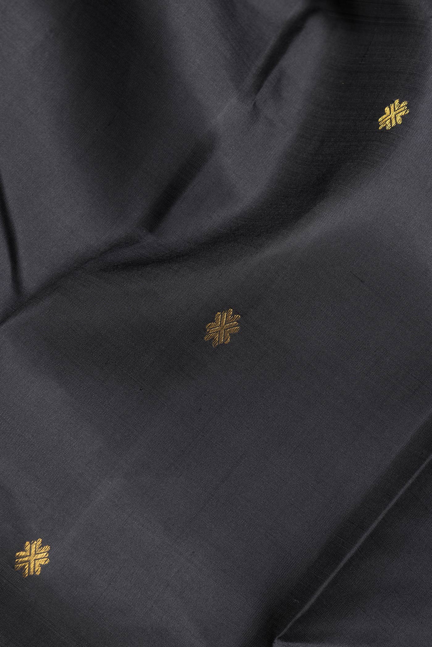 Close up of Black Dual Tone Kanchipuram Silk Saree with Zari Butta on the body and Zari Border.  displaying folds