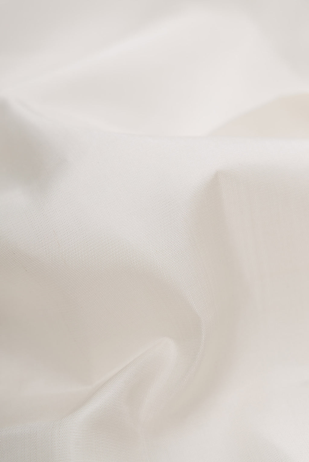 Close up of White Dual Tone Kanjivaram Silk Saree with Plain Body and Zari Border.  displaying folds