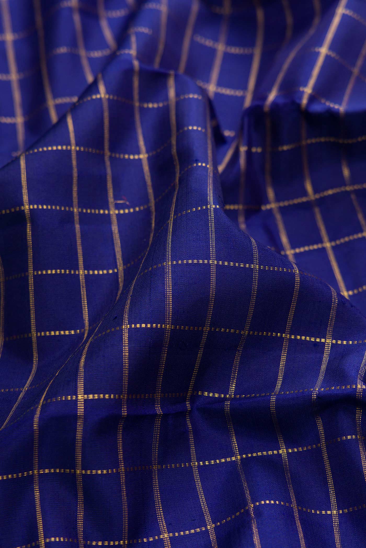 Close up of Navy Blue Dual Tone Kanchipuram Silk Saree with Checked design on the body and Zari Border displaying folds