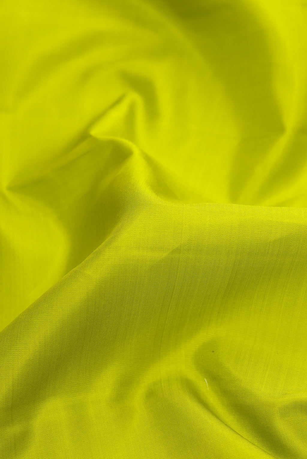 Close up of Parrot Green Dual Tone Kanjivaram Silk Saree with Plain Body and Zari Border.  displaying folds