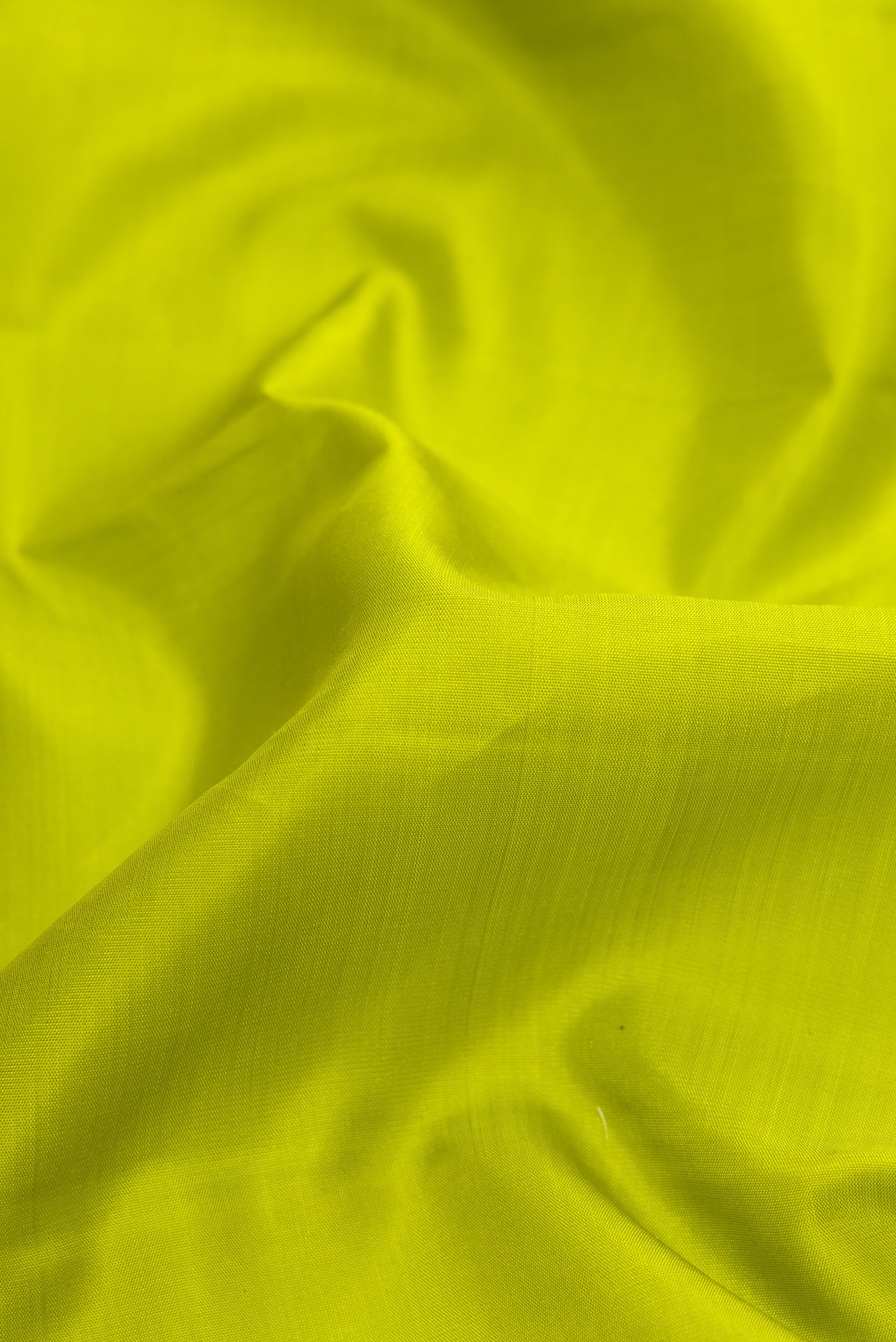 Close up of Parrot Green Dual Tone Kanjivaram Silk Saree with Plain Body and Zari Border.  displaying folds