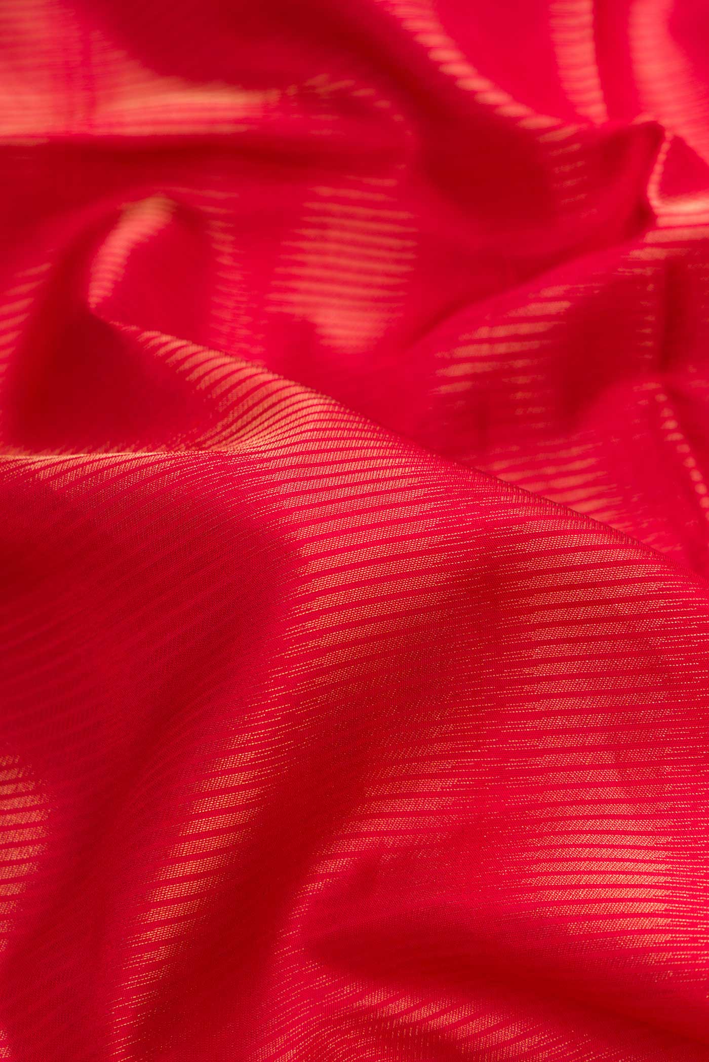 Close up of Red Dual Tone Soft Silk Saree with Zari Brocade on the body and Zari Border.  displaying folds