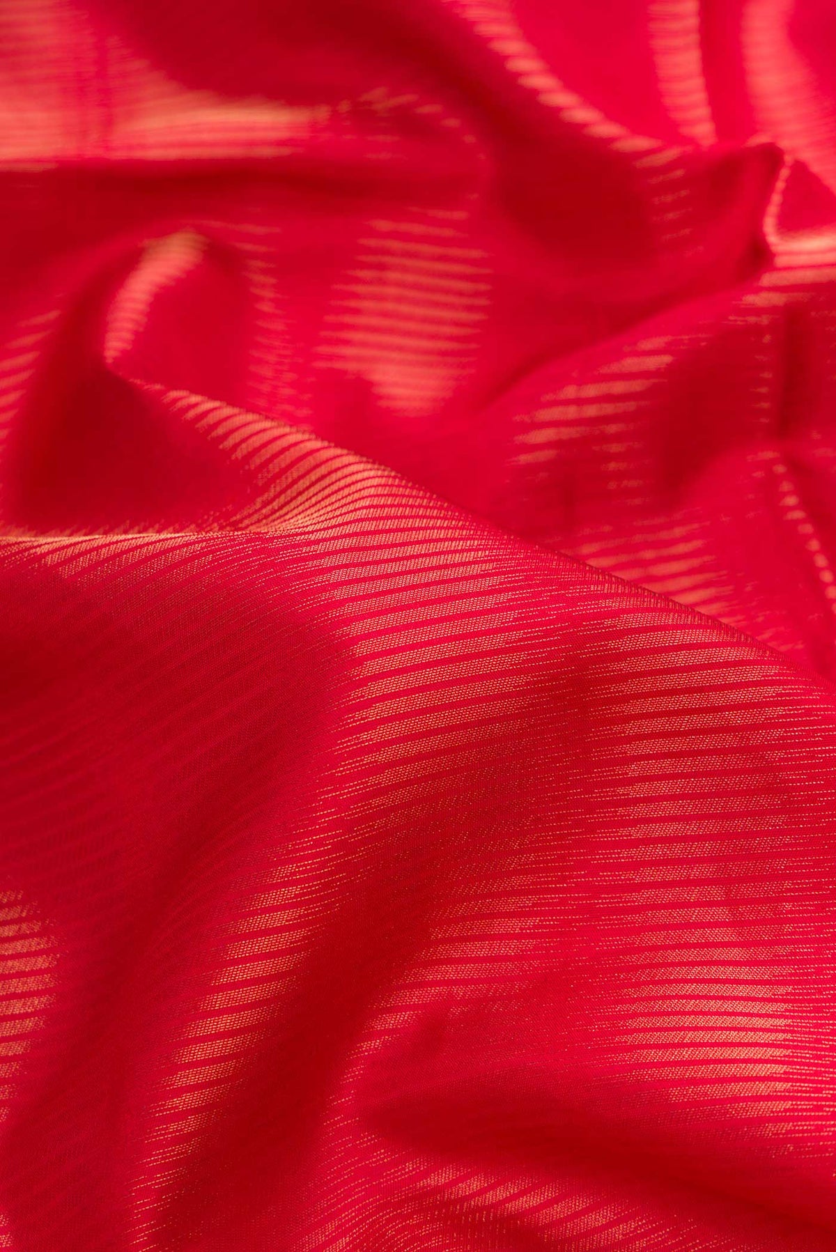 Close up of Red Dual Tone Soft Silk Saree with Zari Brocade on the body and Zari Border.  displaying folds