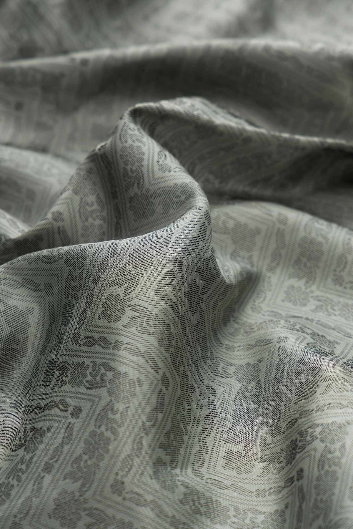 Close up of Grey Dual Tone Soft Silk Saree with Jacquard design on the body and Thread Border displaying folds
