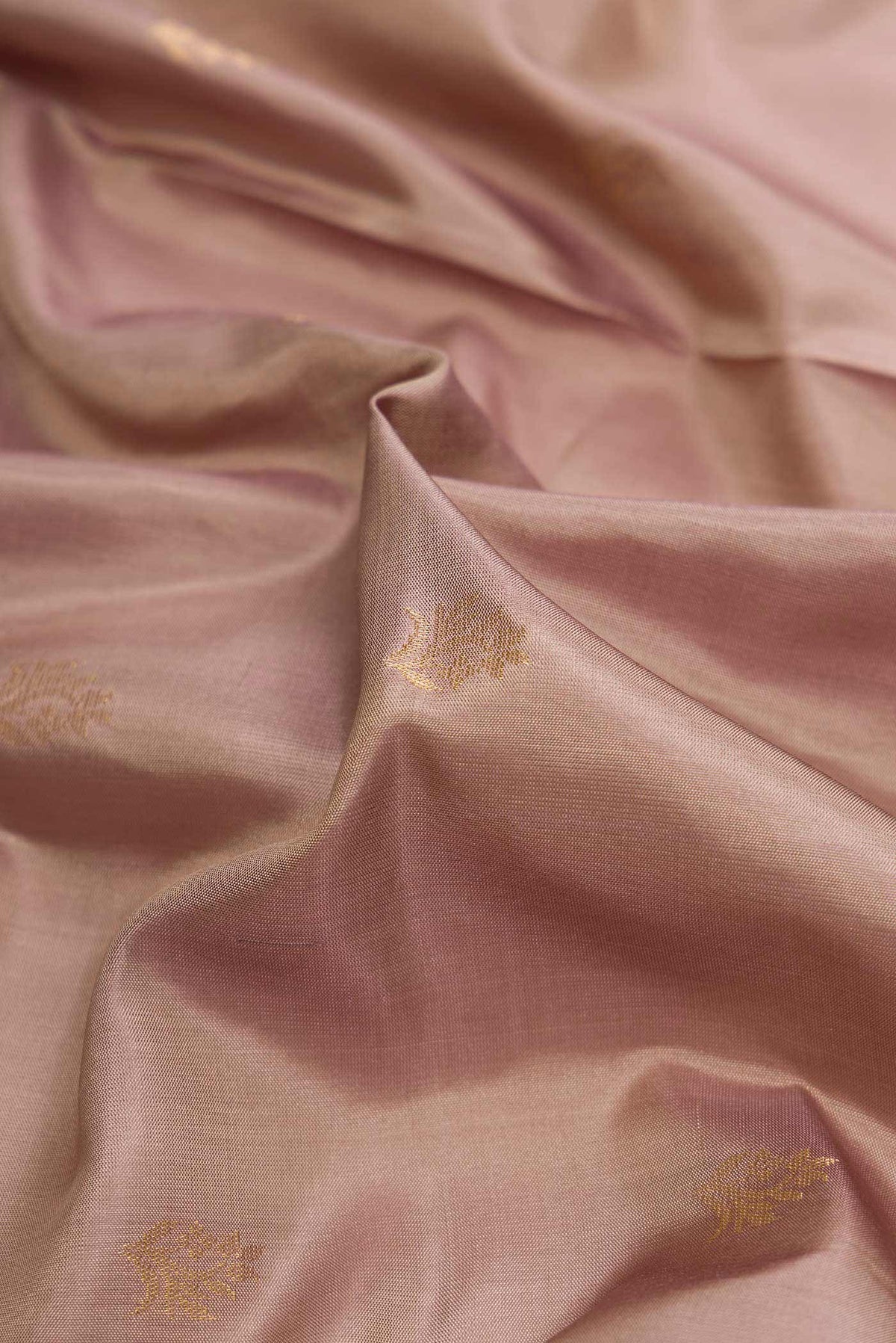 Close up of Rose Gold Dual Tone Soft Silk Saree with Zari Butta on the body and Zari Border displaying folds