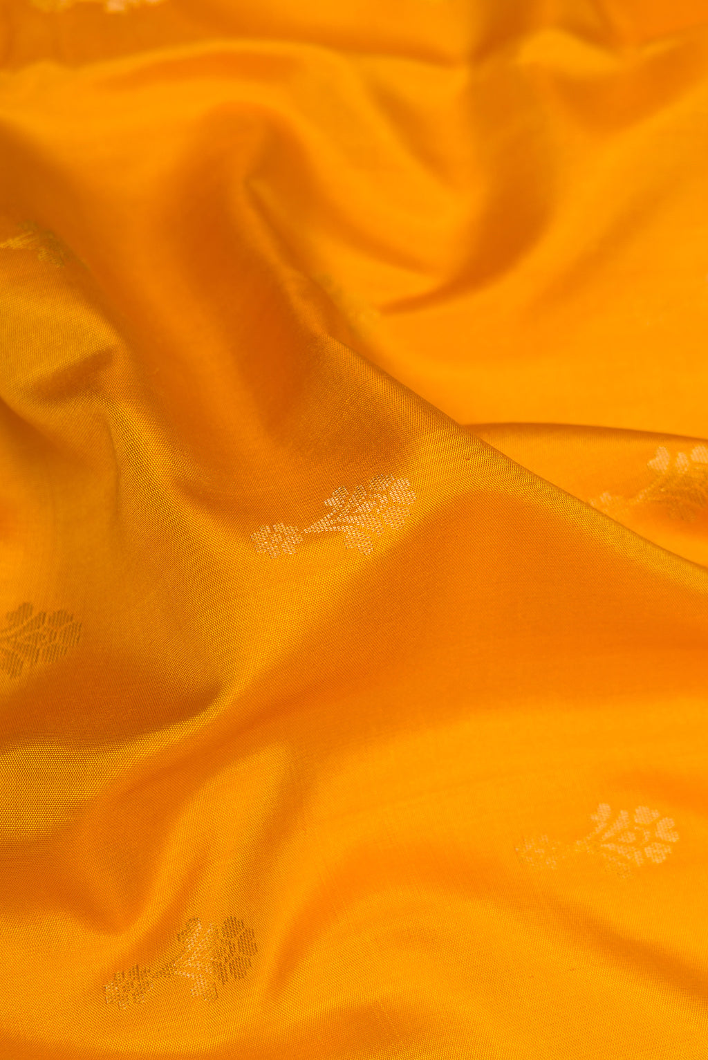 Close up of Yellow Dual Tone Soft Silk Saree with Zari Butta on the body and Zari Border.  displaying folds