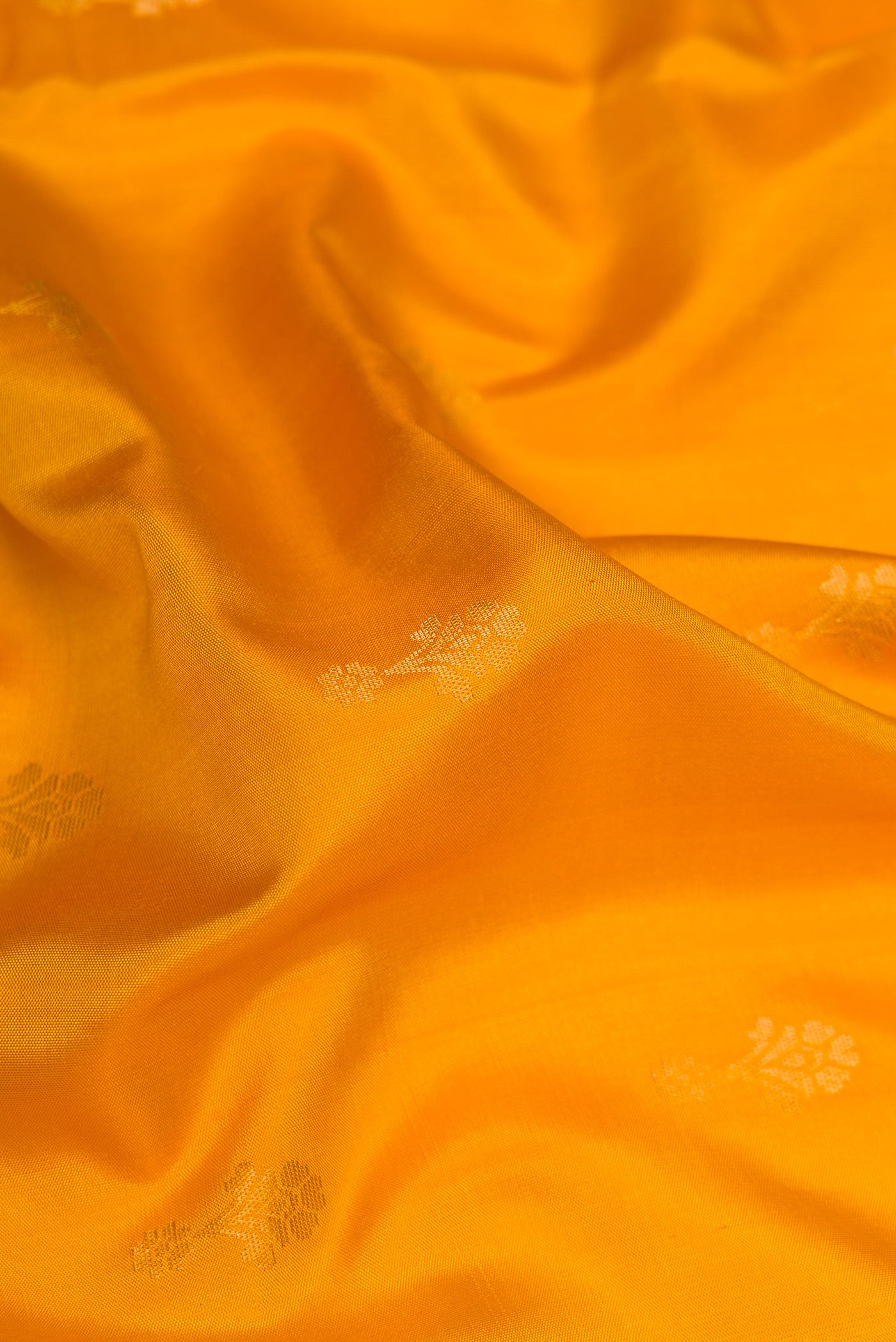 Close up of Yellow Dual Tone Soft Silk Saree with Zari Butta on the body and Zari Border.  displaying folds