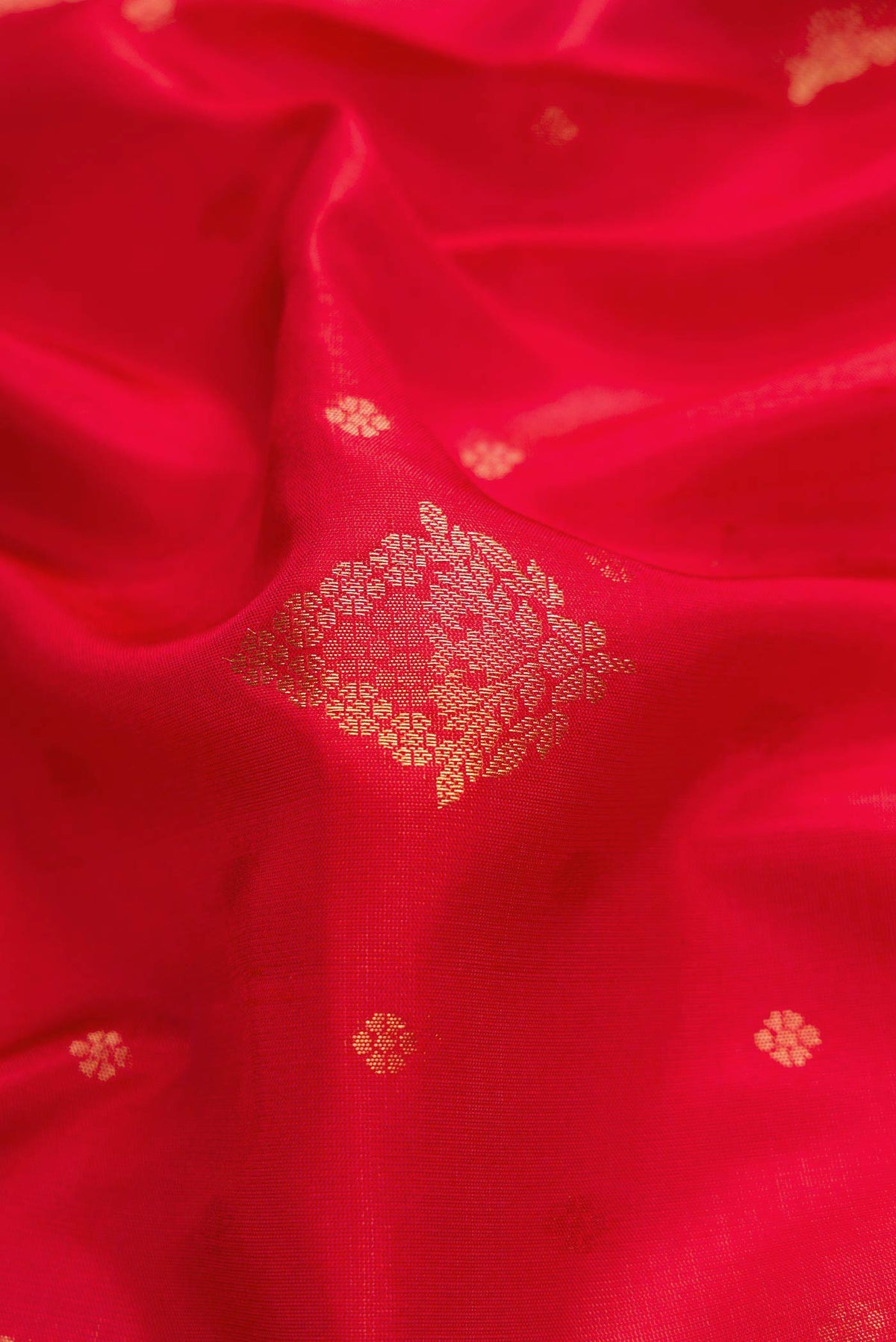 Close up of Red Dual Tone Soft Silk Saree with Zari Butta on the body and Zari Border displaying folds