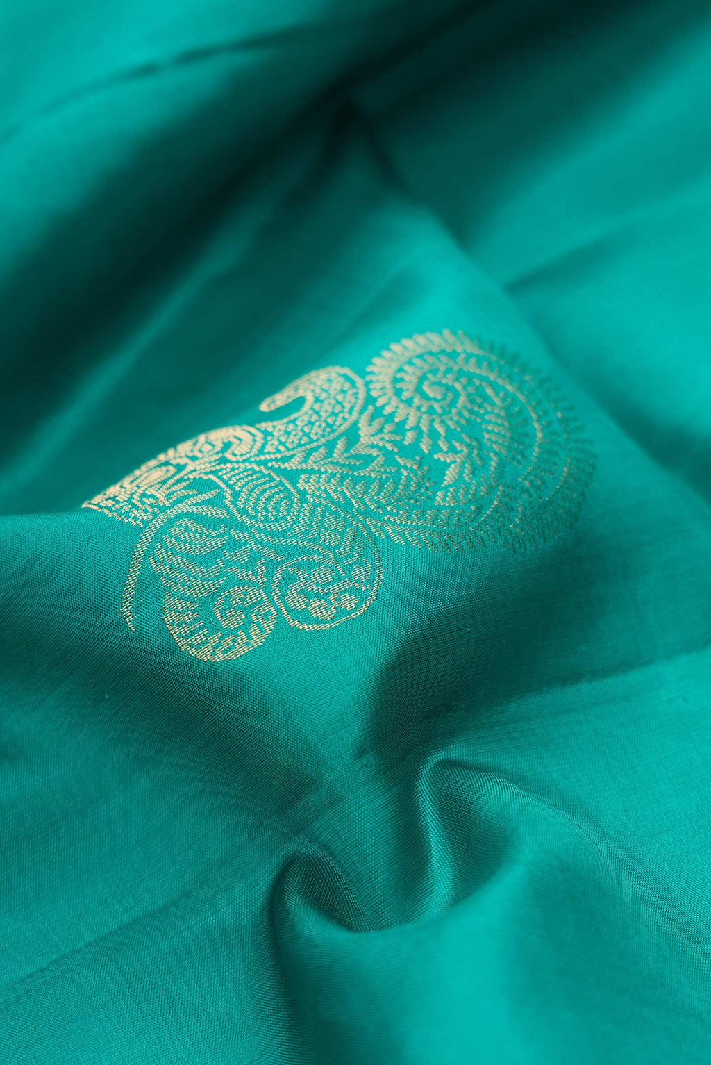 Close up of Green Dual Tone Soft Silk Saree with Zari Butta on the body and Without Border.  displaying folds
