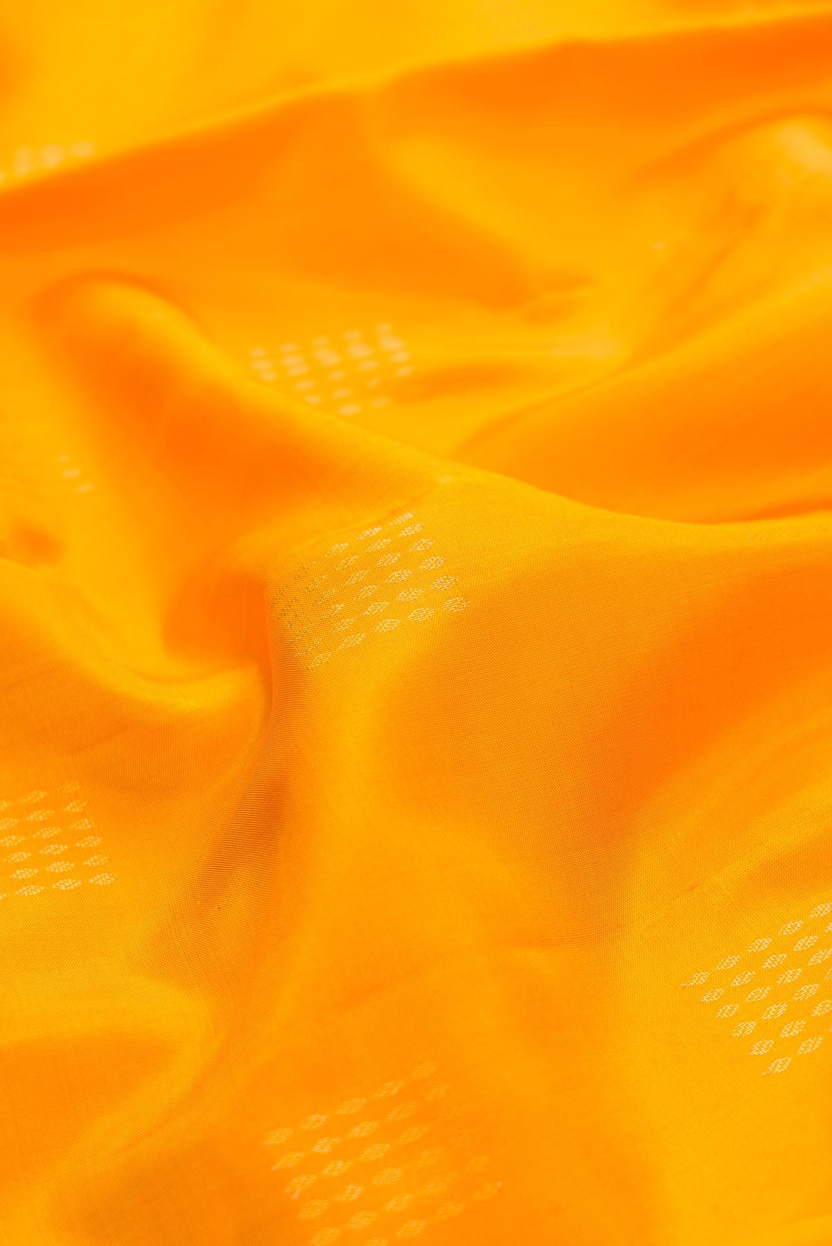 Close up of Yellow Dual Tone Soft Silk Saree with Zari Butta on the body and Zari Border displaying folds
