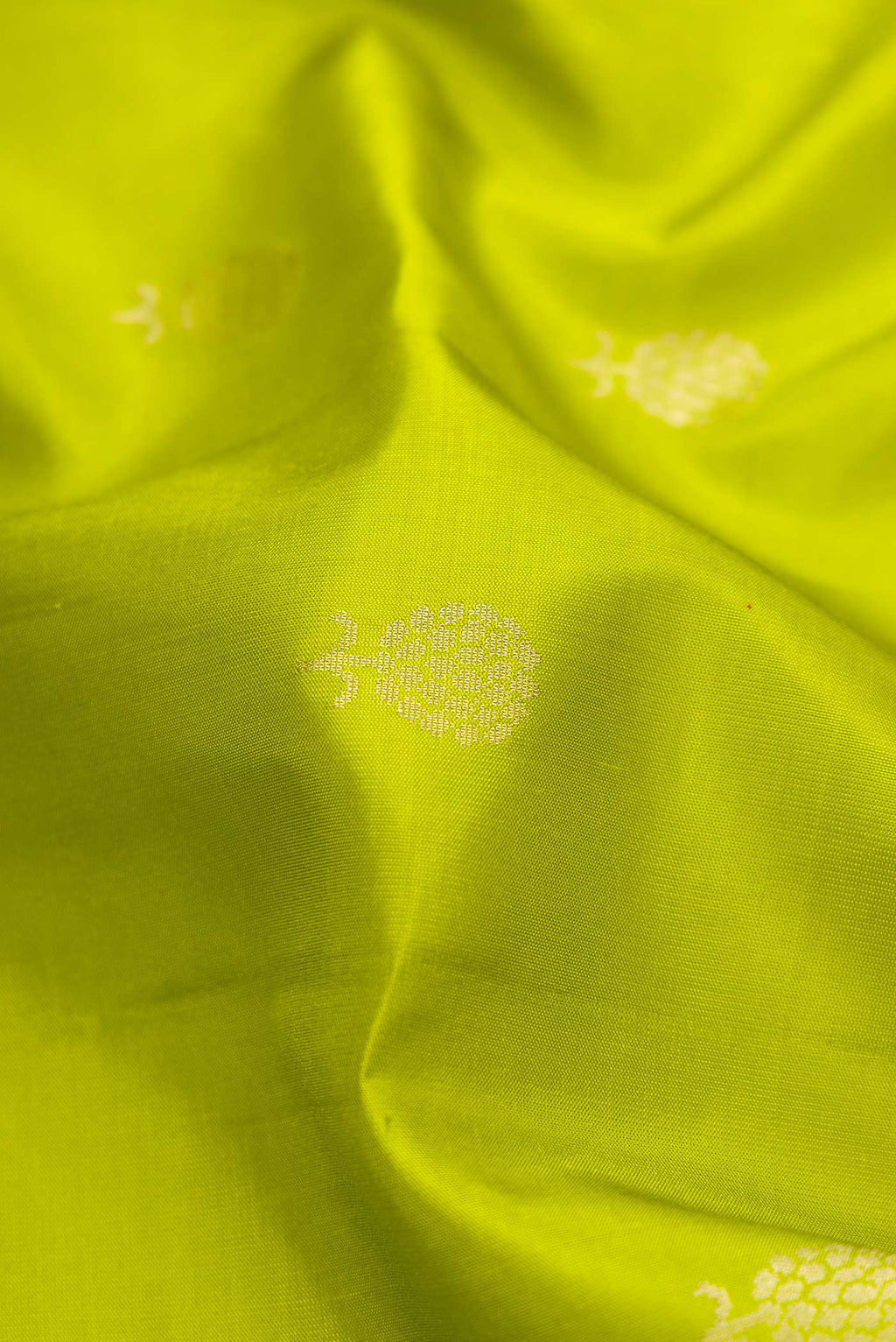 Close up of Parrot Green Dual Tone Soft Silk Saree with Zari Butta on the body and Zari Border.  displaying folds