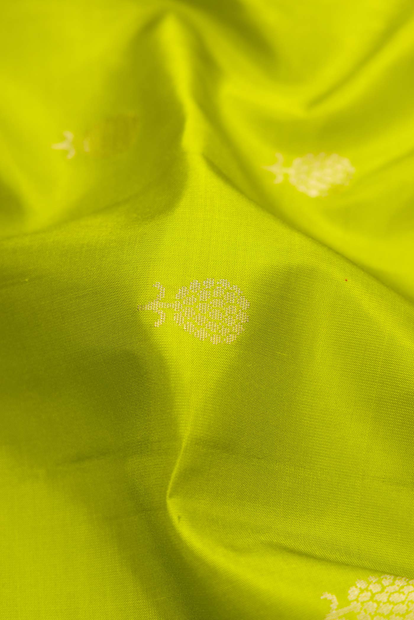 Close up of Parrot Green Dual Tone Soft Silk Saree with Zari Butta on the body and Zari Border.  displaying folds