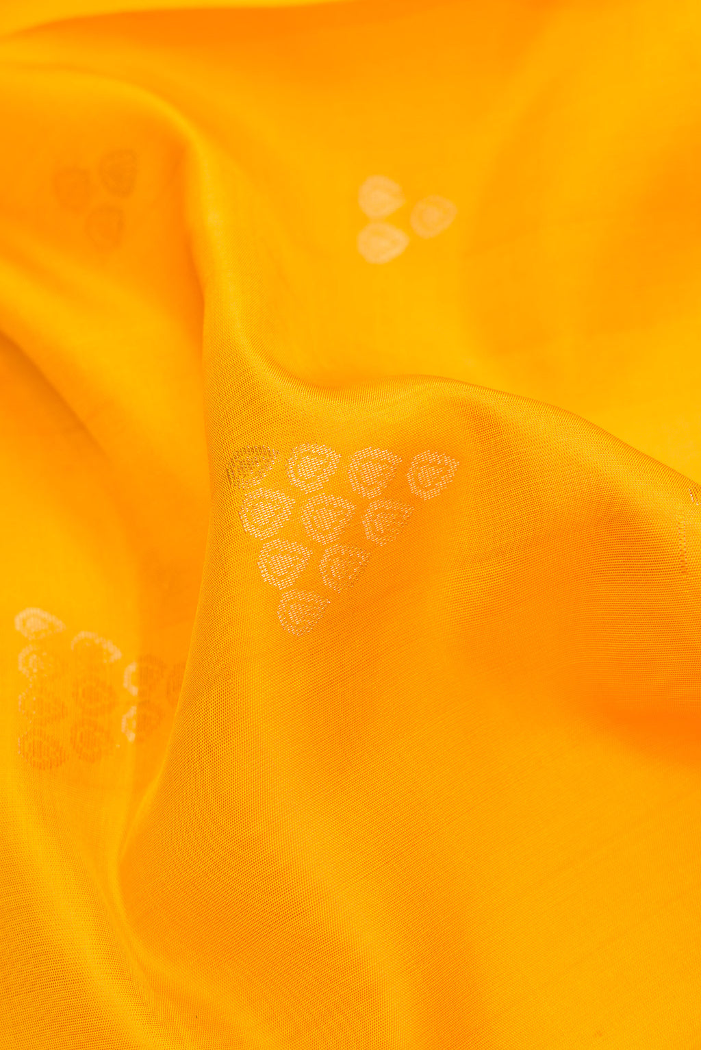 Close up of Yellow Dual Tone Soft Silk Saree with Zari Butta on the body and Zari Border.  displaying folds
