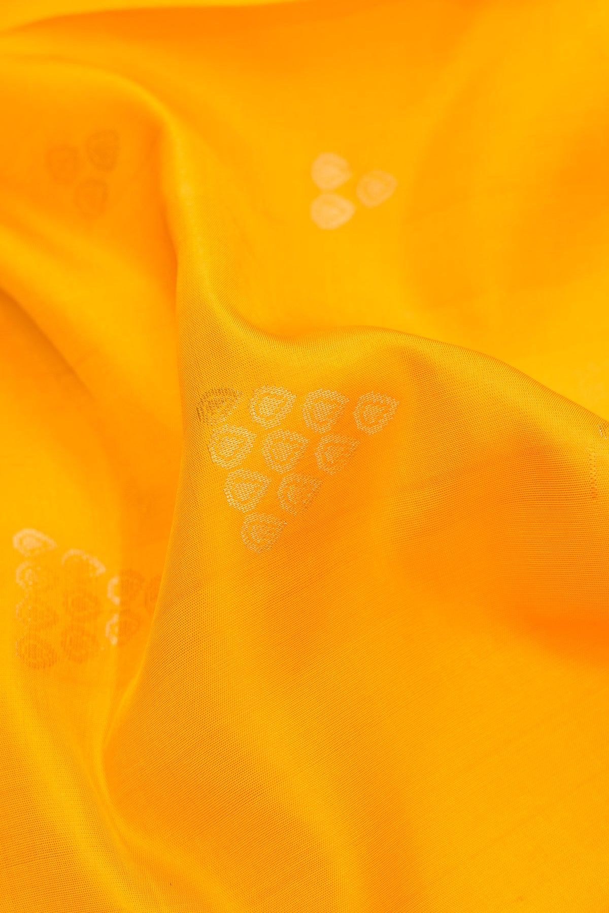 Close up of Yellow Dual Tone Soft Silk Saree with Zari Butta on the body and Zari Border.  displaying folds