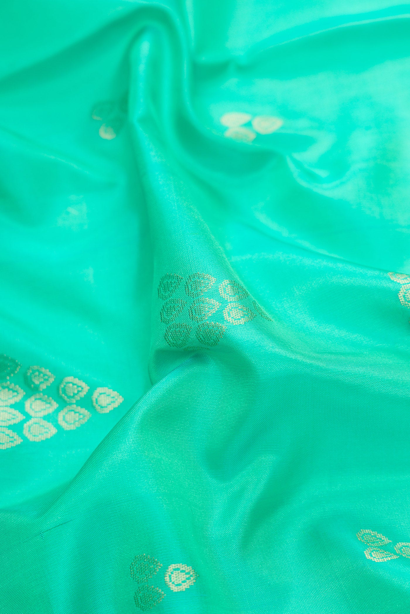 Close up of Sea Green Dual Tone Soft Silk Saree with Zari Butta on the body and Zari Border.  displaying folds