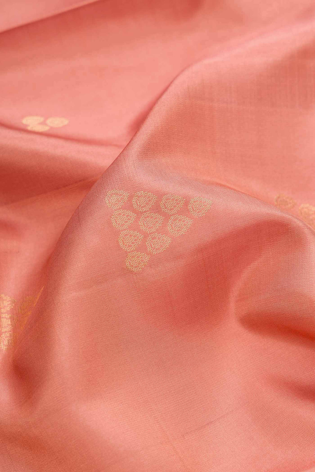 Close up of Golden Peach Dual Tone Soft Silk Saree with Zari Butta on the body and Zari Border.  displaying folds