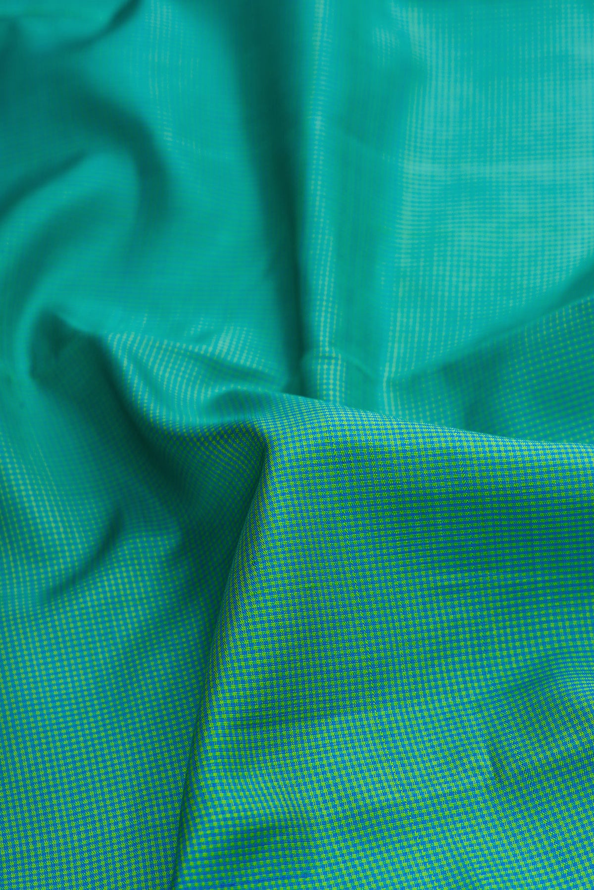 Close up of Light Green Dual Tone Kanjivaram Silk Saree with Checked design on the body and Temple Thread Border.  displaying folds