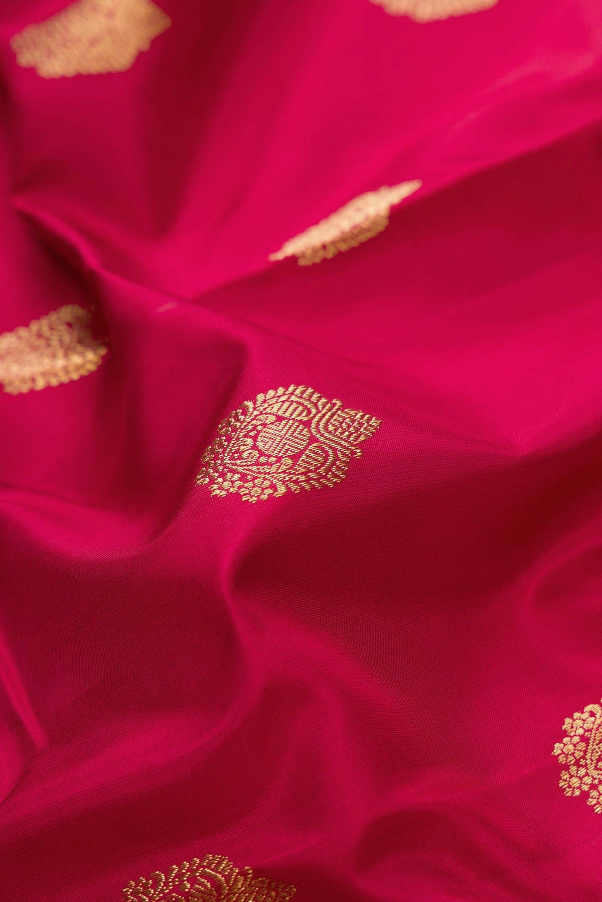 Close up of Pure Silk Pure Zari Maroon Dual Tone Kanjivaram Saree with Zari Butta on the body and Zari Border.  displaying folds