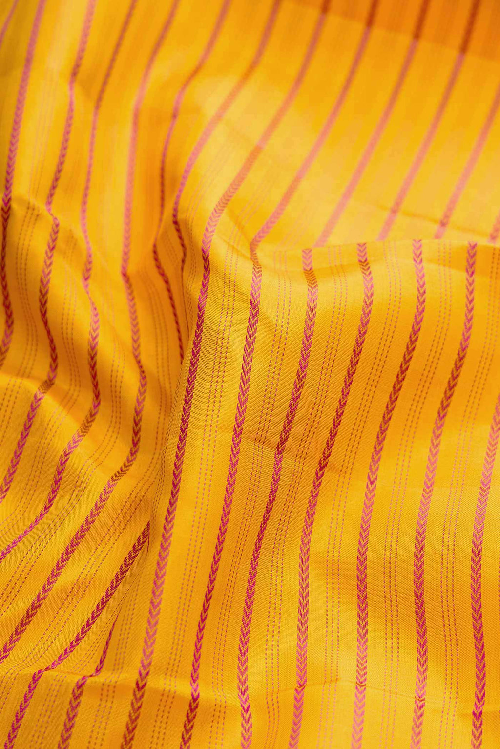 Close up of Pure Silk Pure Zari Mustard Dual Tone Kanchipuram Saree with Veldhari on the body and Zari Border displaying folds