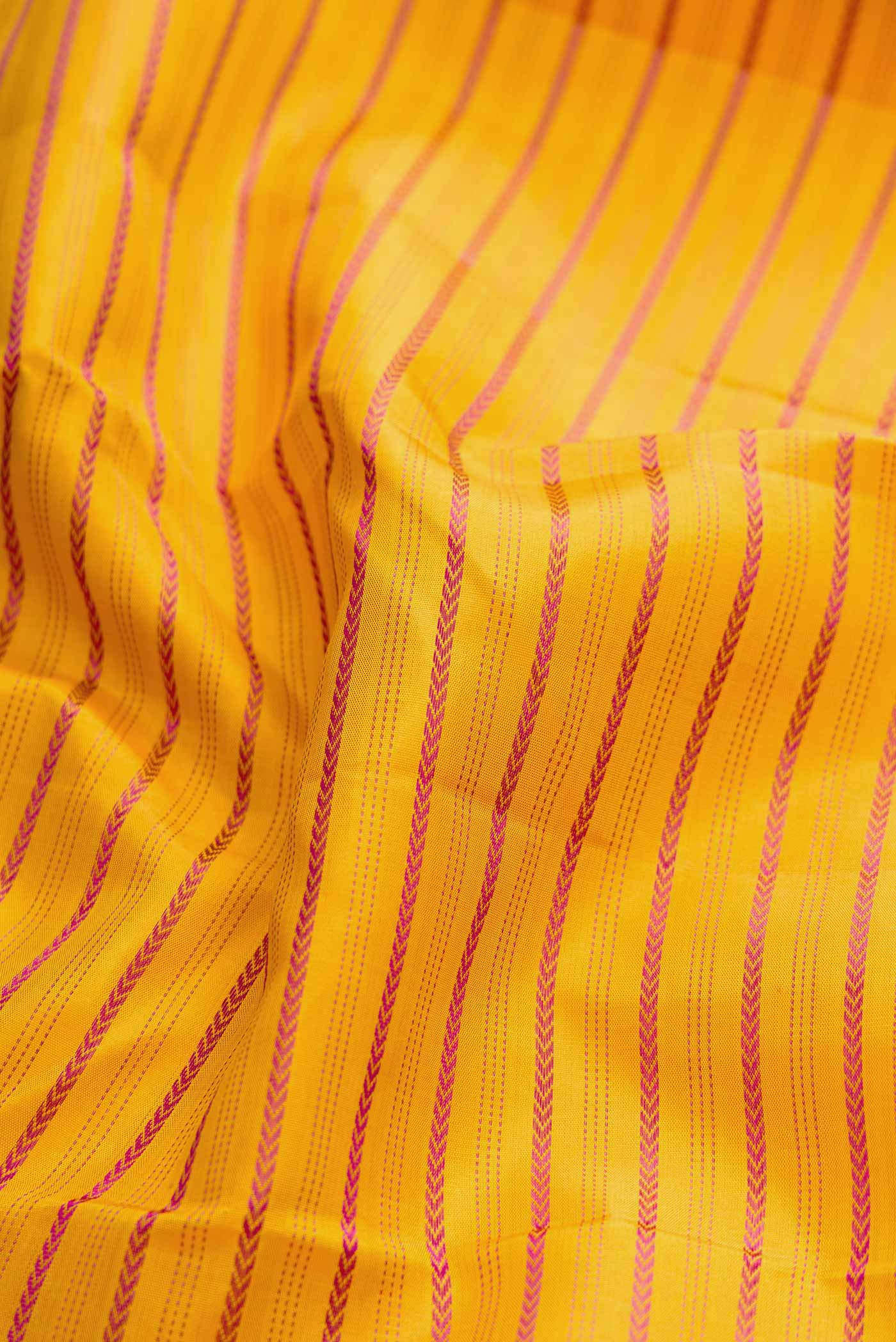 Close up of Pure Silk Pure Zari Mustard Dual Tone Kanchipuram Saree with Veldhari on the body and Zari Border displaying folds