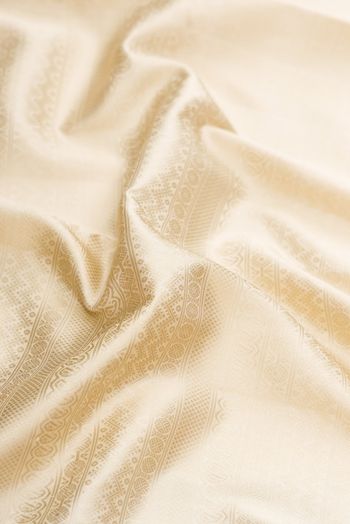 Close up of Off White Dual Tone Kanjivaram Silk Saree with Jacquard design on the body and Zari Border.  displaying folds