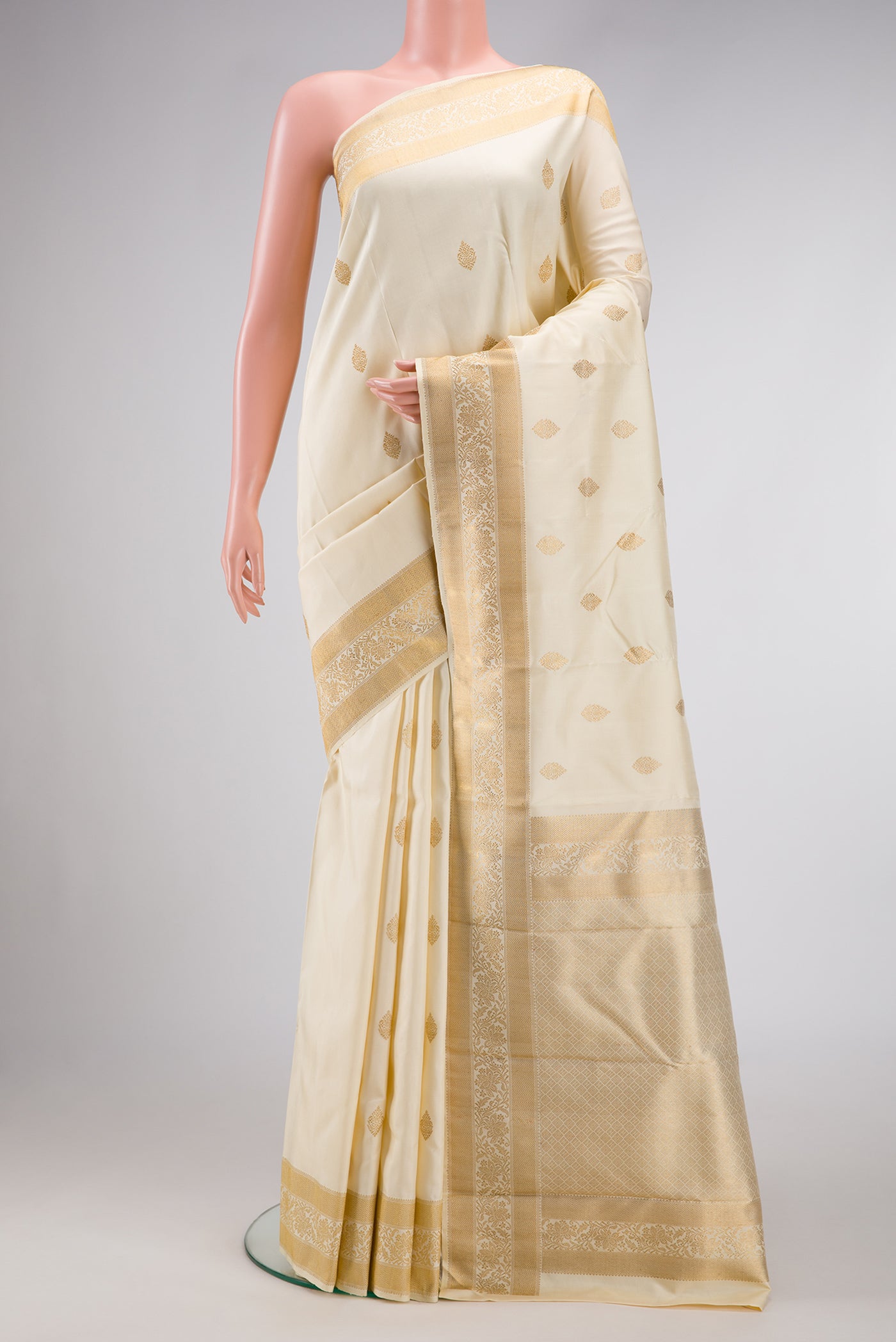 Pure Silk Pure Zari Off White Dual Tone Kanjivaram Saree with Zari Butta on the body and Zari Border.  displayed on a mannequin